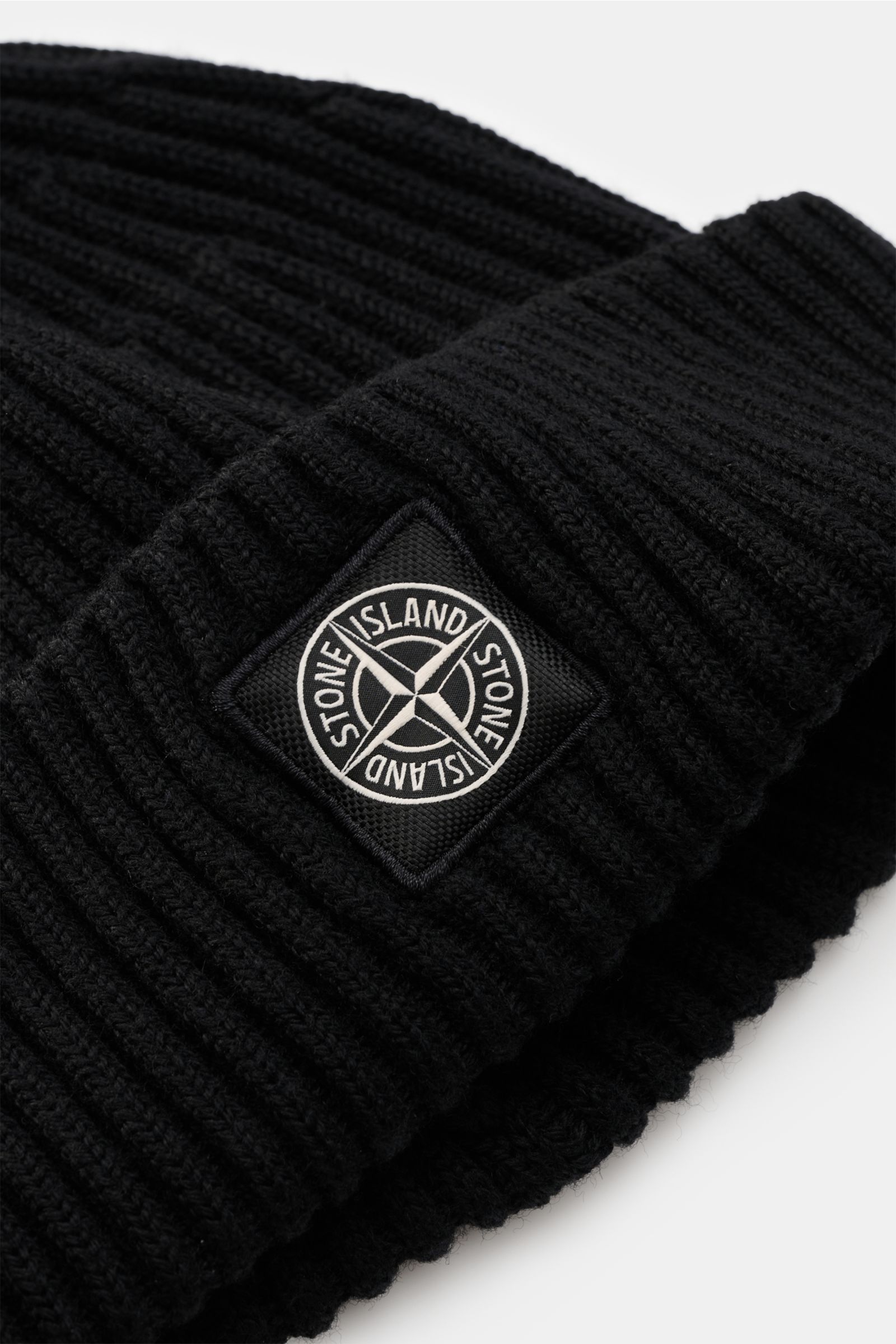 Close-up front-side view of the Stone Island Wool beanie black, showing pure wool, soft feel, modern rib knit look, wide turn-up, and front with STONE ISLAND woven label.