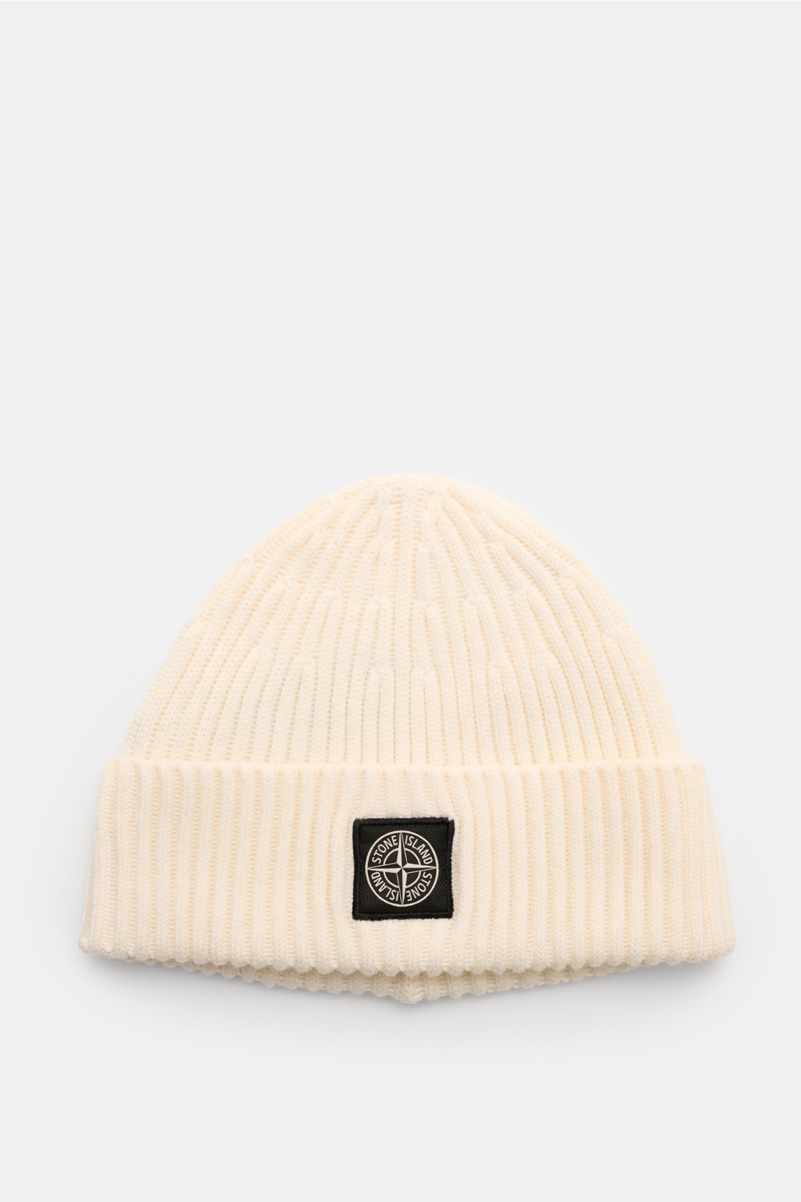 Stone Island Wollmütze creme, frontale Ansicht, reine Wolle, weicher Griff, moderne Rippstrick-Optik, breiter Umschlag mit STONE ISLAND-Weblabel.