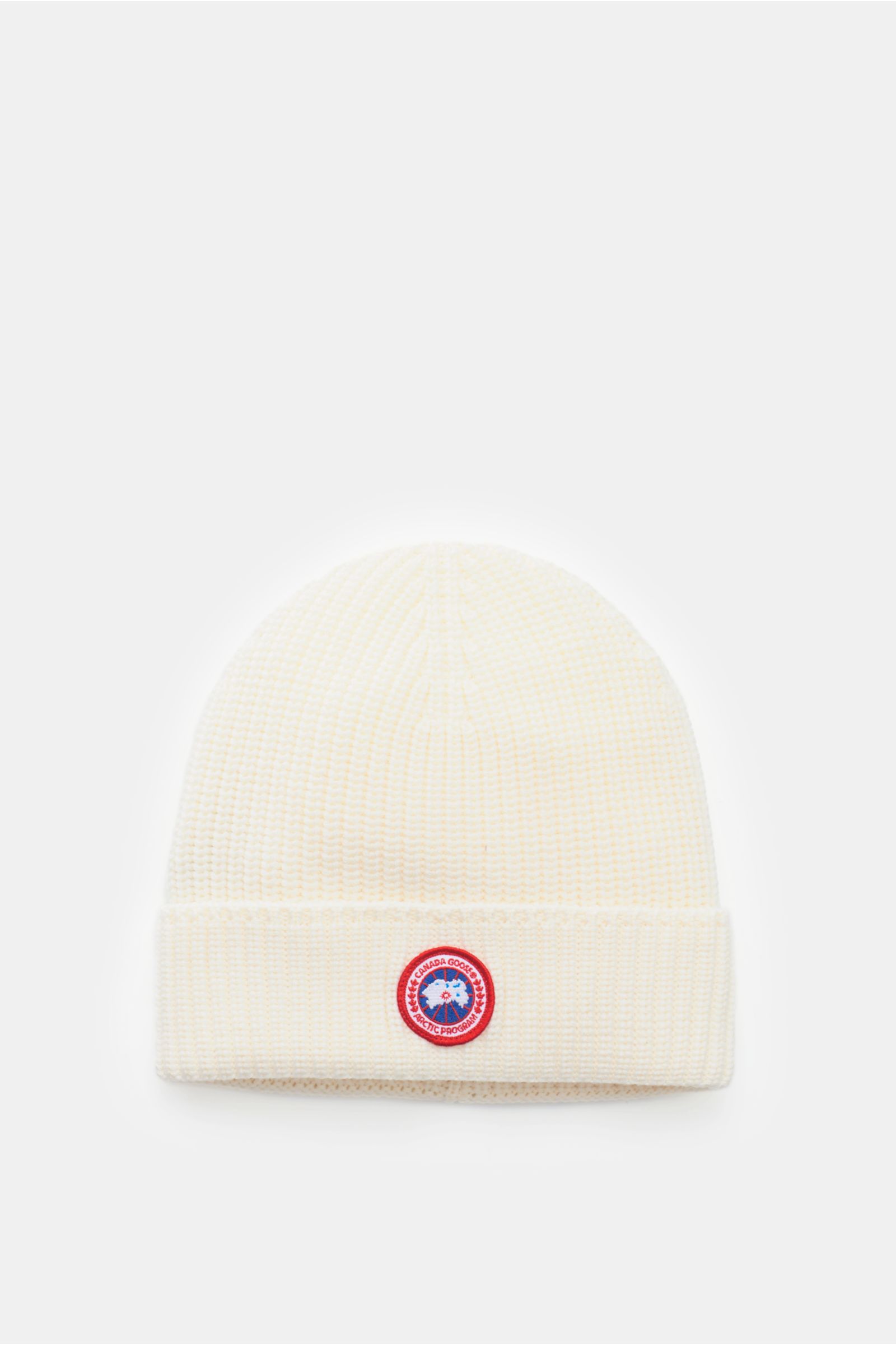 Canada Goose Wollmütze creme aus reiner Wolle, grober Rippstrick, griffige Qualität, mit Umschlag und Weblabel, frontal fotografiert.