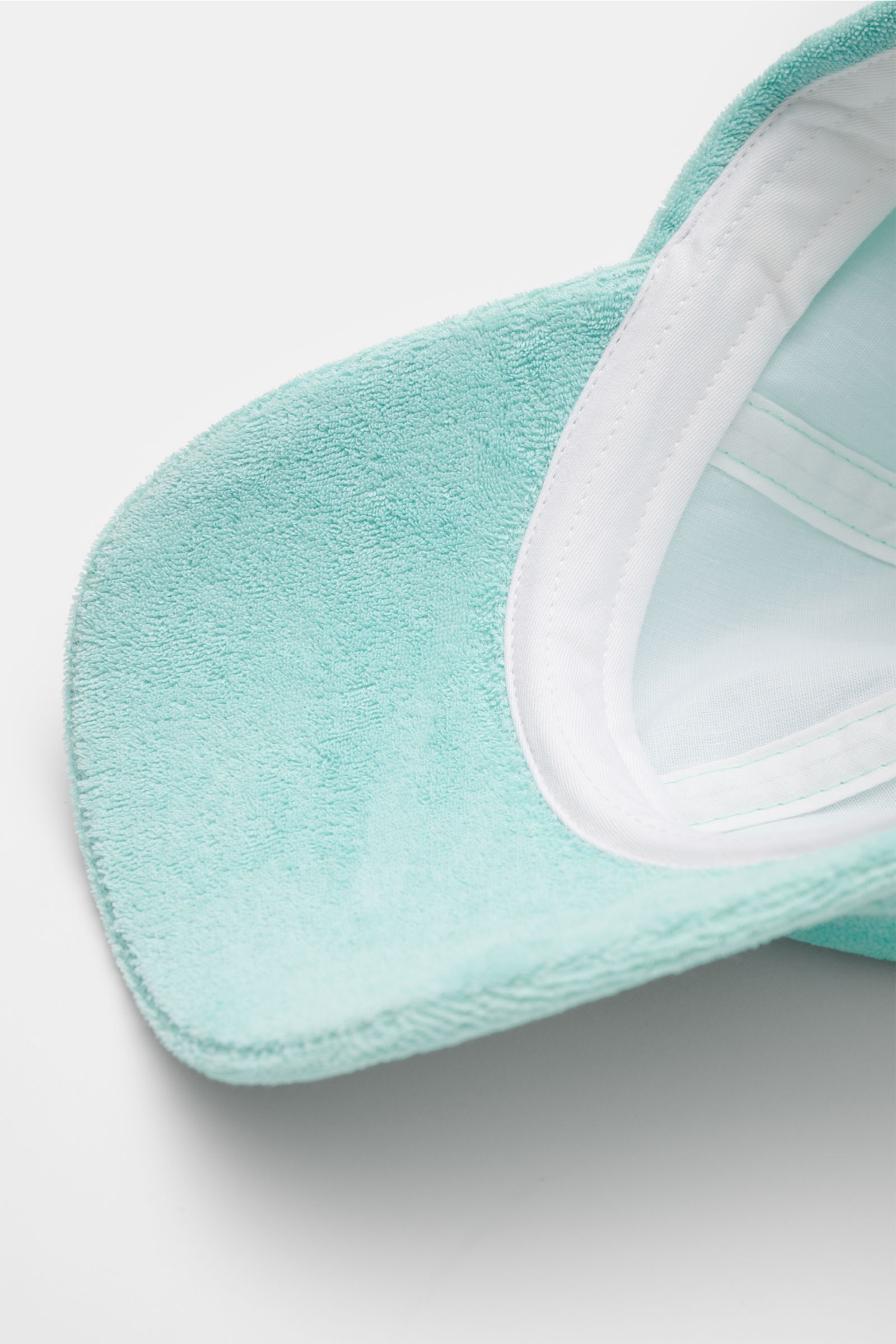 04651/ A trip in a bag Frottee-Cap 'Oyster' mintgrün in Nahaufnahme von unten, weiche Baumwoll-Frottee-Qualität, verstellbarer Verschluss, dezentes Weblabel.