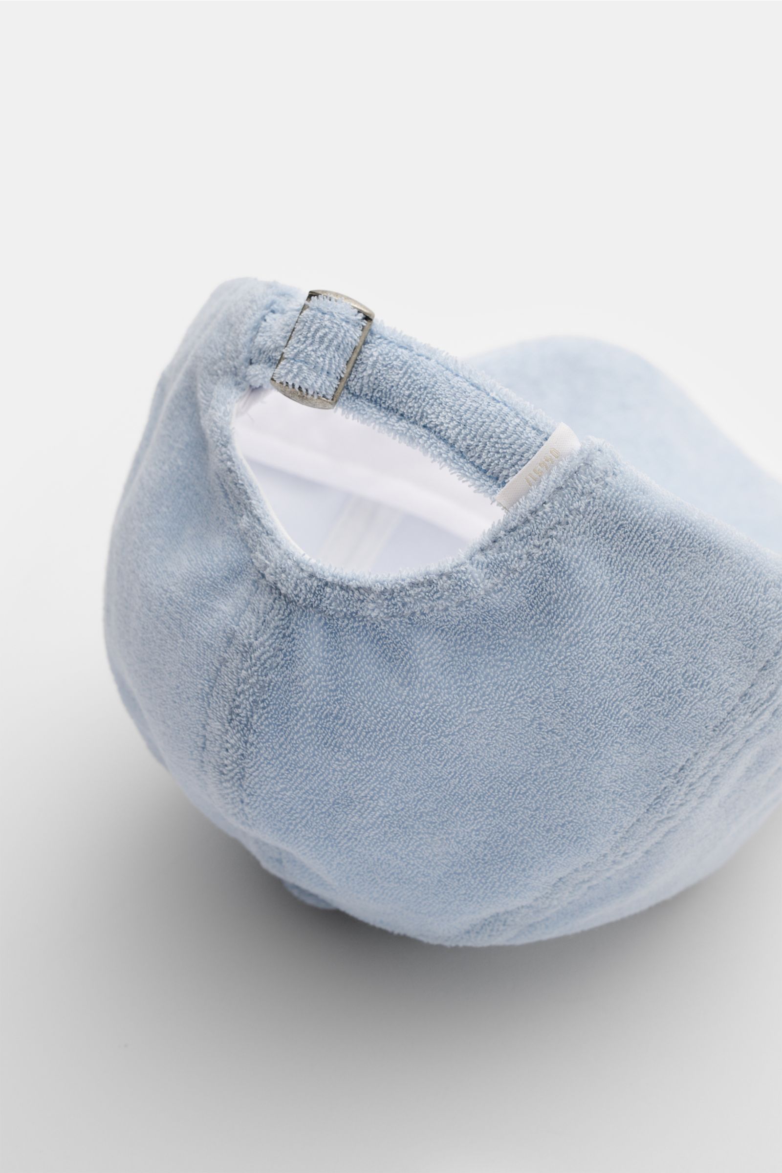 Light blue 04651/ A trip in a bag Frottee-Cap 'Oyster' photographed from the back right side, showing soft cotton terry fabric, adjustable strap with metal buckle, and subtle back label. Das sportlich-stylishe Baseball-Cap des Sylter Labels 04651/ A TR