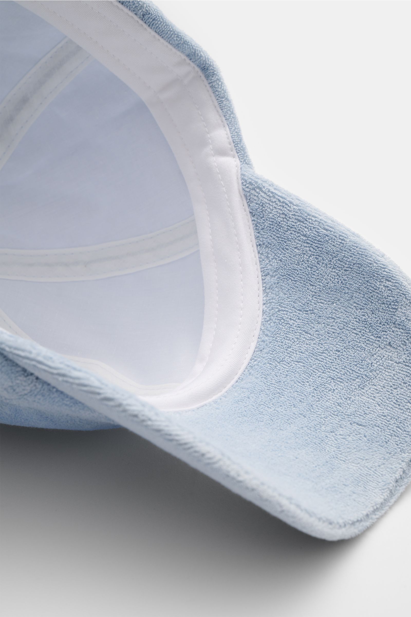 Close-up inside view of the 04651/ A trip in a bag Frottee-Cap 'Oyster' hellblau showing soft light blue terry cotton fabric and white inner band.

Additional description: Das sportlich-stylishe Baseball-Cap des Sylter Labels 04651/ A TRIP IN A BAG beg