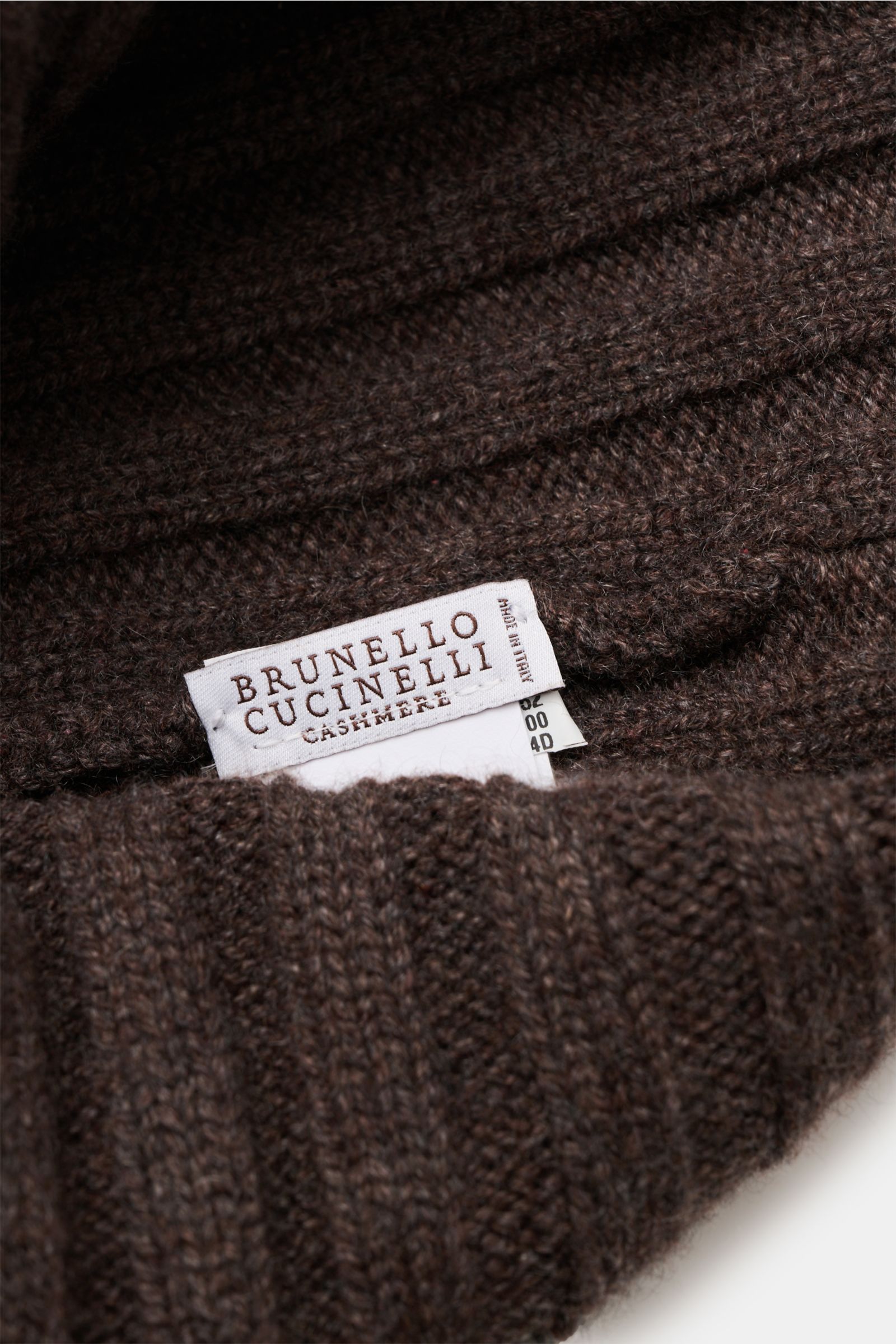 Brunello Cucinelli Cashmere Mütze braun meliert shown close-up from above, highlighting ribbed knit and label. Diese Mütze aus edlem Cashmere im zeitlosen Rippstrick-Design von BRUNELLO CUCINELLI bringt behagliche Wärme und luxuriösen Komfort in unsere