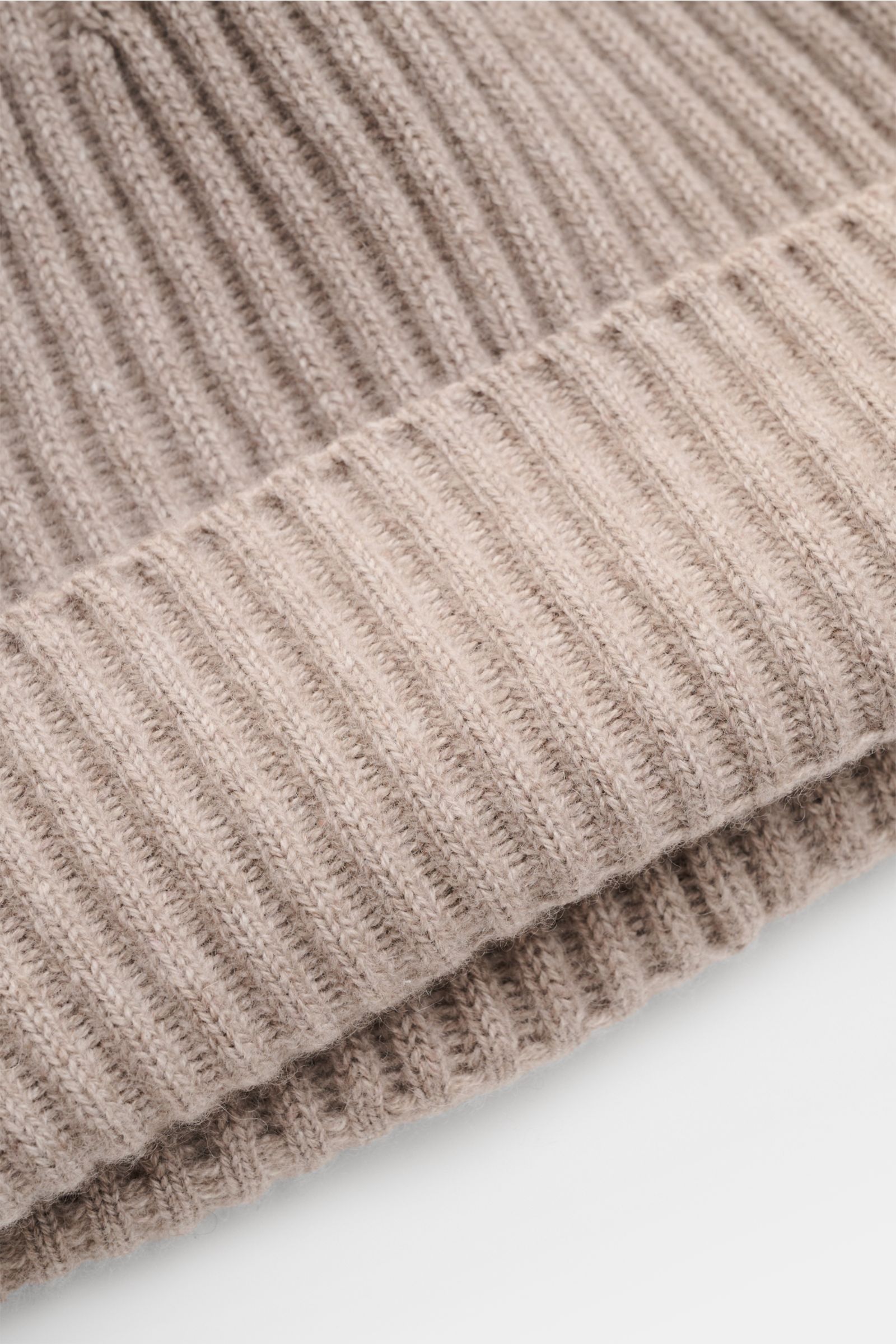 Brunello Cucinelli Cashmere beanie taupe mottled shown from a close-up angled top view, highlighting ribbed knit and wide turn-up. This beanie in fine cashmere and a timeless ribbed knit by BRUNELLO CUCINELLI brings cosy warmth and luxurious comfort to