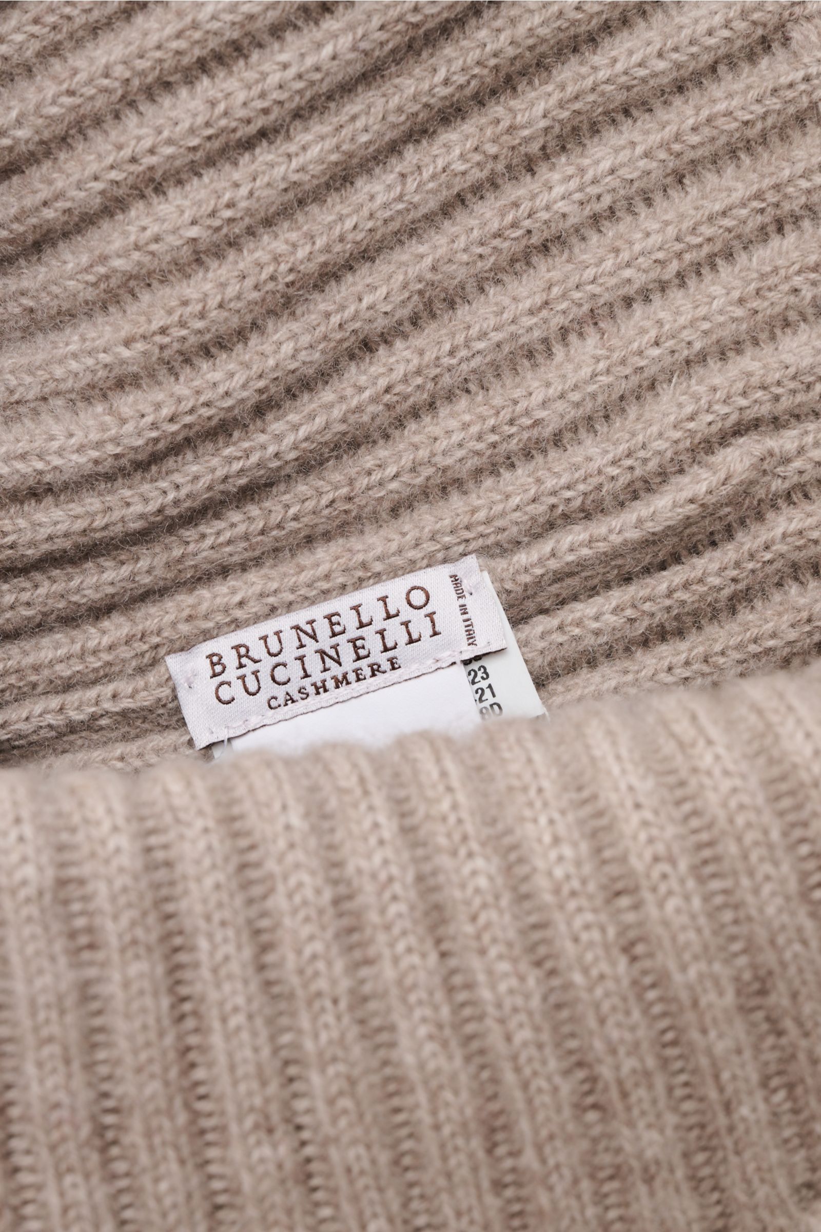 Close-up front view of Brunello Cucinelli Cashmere beanie taupe mottled, showing distinctive rib knit and wide turn-up with label.

This beanie in fine cashmere and a timeless ribbed knit by BRUNELLO CUCINELLI brings cosy warmth and luxurious comfort t