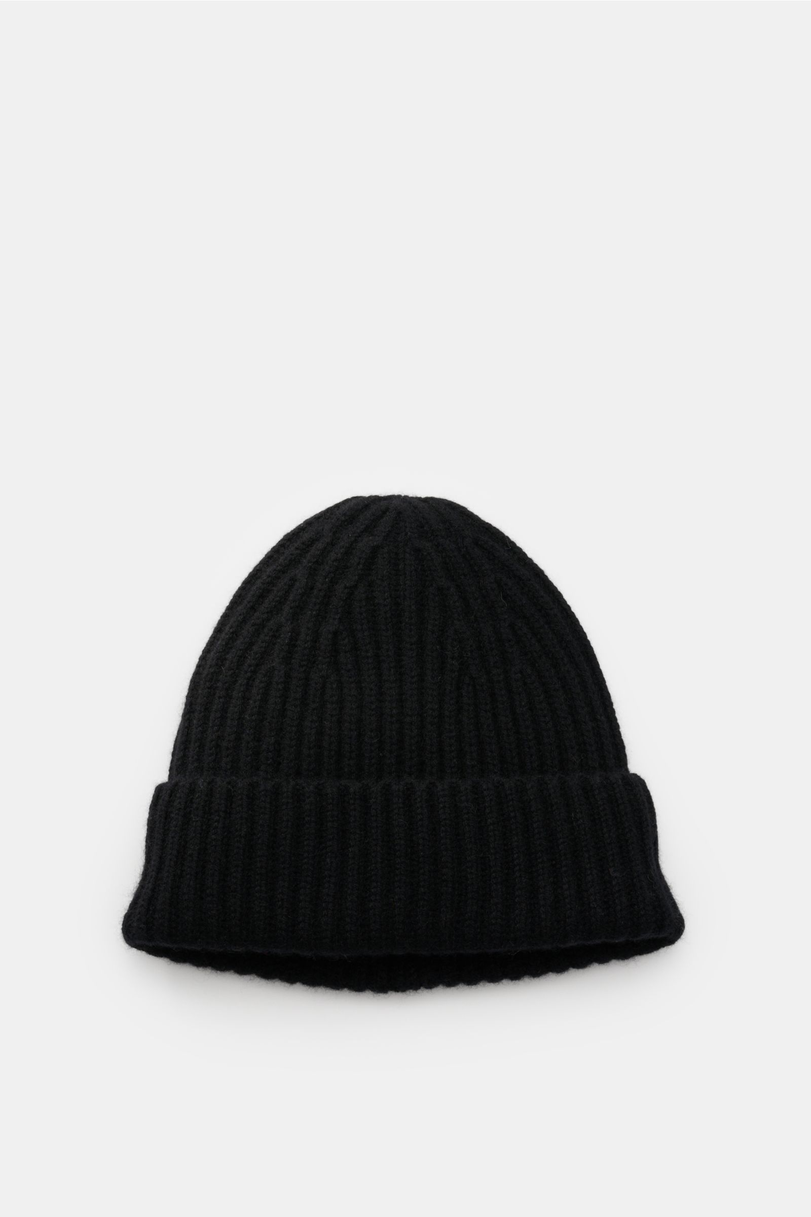 Black knitted beanie photographed from above on a white background. Luxus für kalte Tage – die Mütze 'Menton' von LISA YANG bringt Wärme und Stil in Ihr Winter-Outfit. Gefertigt aus reinem Cashmere mit softem Griff, überzeugt sie durch ihr markantes Paten