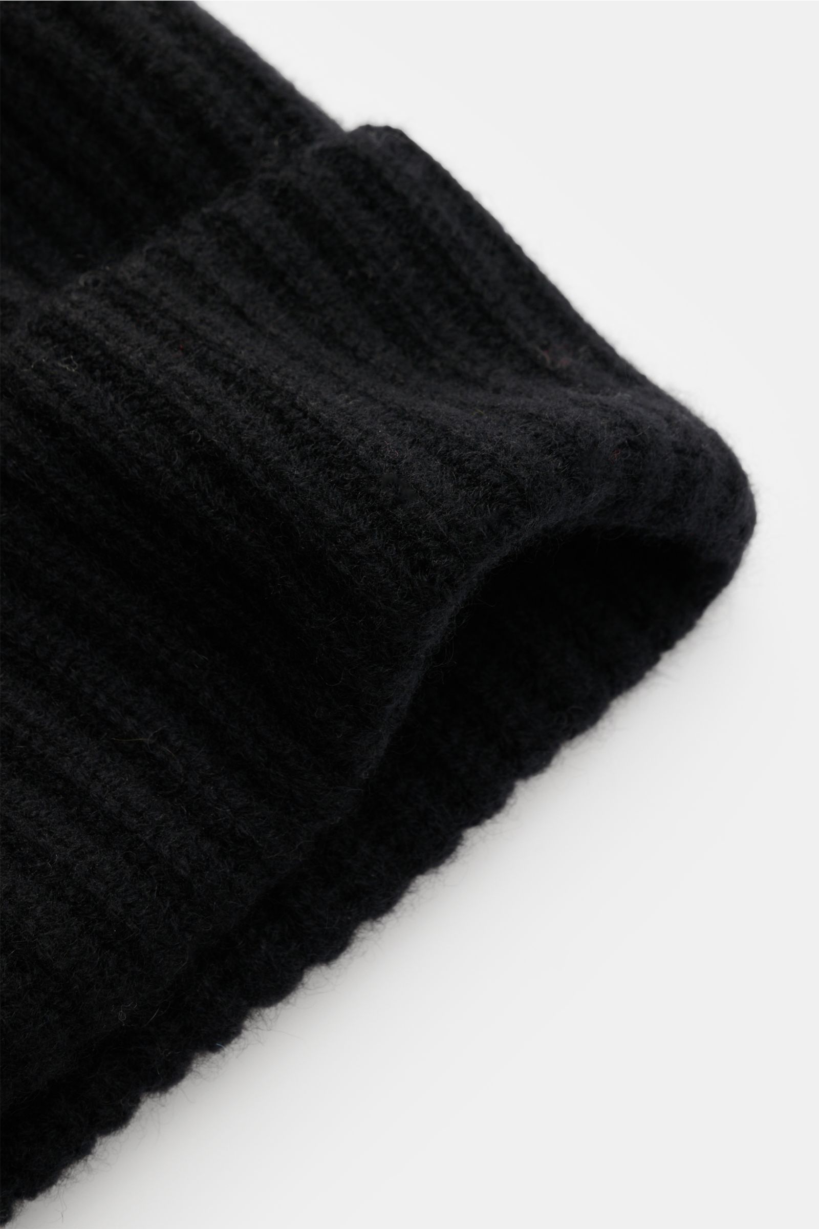 Close-up side view of Lisa Yang Cashmere Mütze 'Menton' schwarz, a black pure cashmere beanie with soft feel, patent stitch, medium knit, and classic cuff.

Luxus für kalte Tage – die Mütze 'Menton' von LISA YANG bringt Wärme und Stil in Ihr Winter-Out