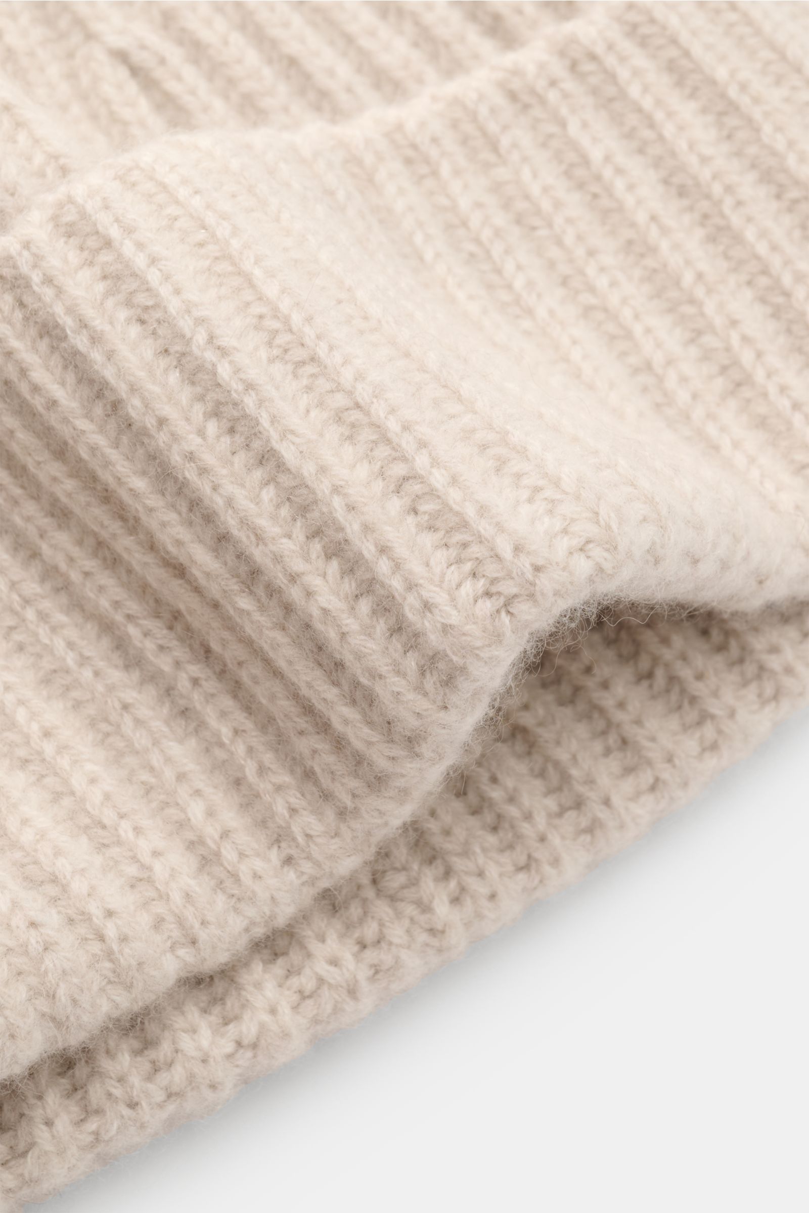 Close-up front-side view of Lisa Yang Cashmere Mütze 'Menton' sand, showing soft, pure cashmere with a classic patent knit and folded cuff. Luxus für kalte Tage – die Mütze 'Menton' von LISA YANG bringt Wärme und Stil in Ihr Winter-Outfit. Gefertigt aus r