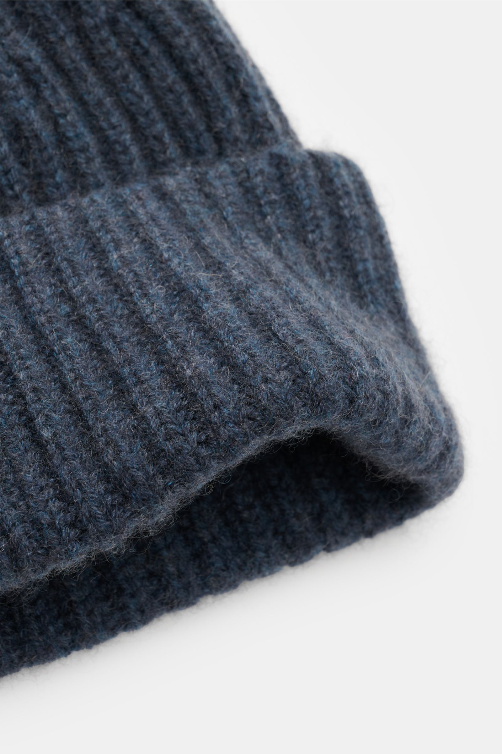 Close-up front-side view of Lisa Yang Cashmere Mütze 'Menton' graublau, a grey-blue pure cashmere hat with soft feel, patent knit pattern, medium knit, and classic cuff, luxury for cold days.