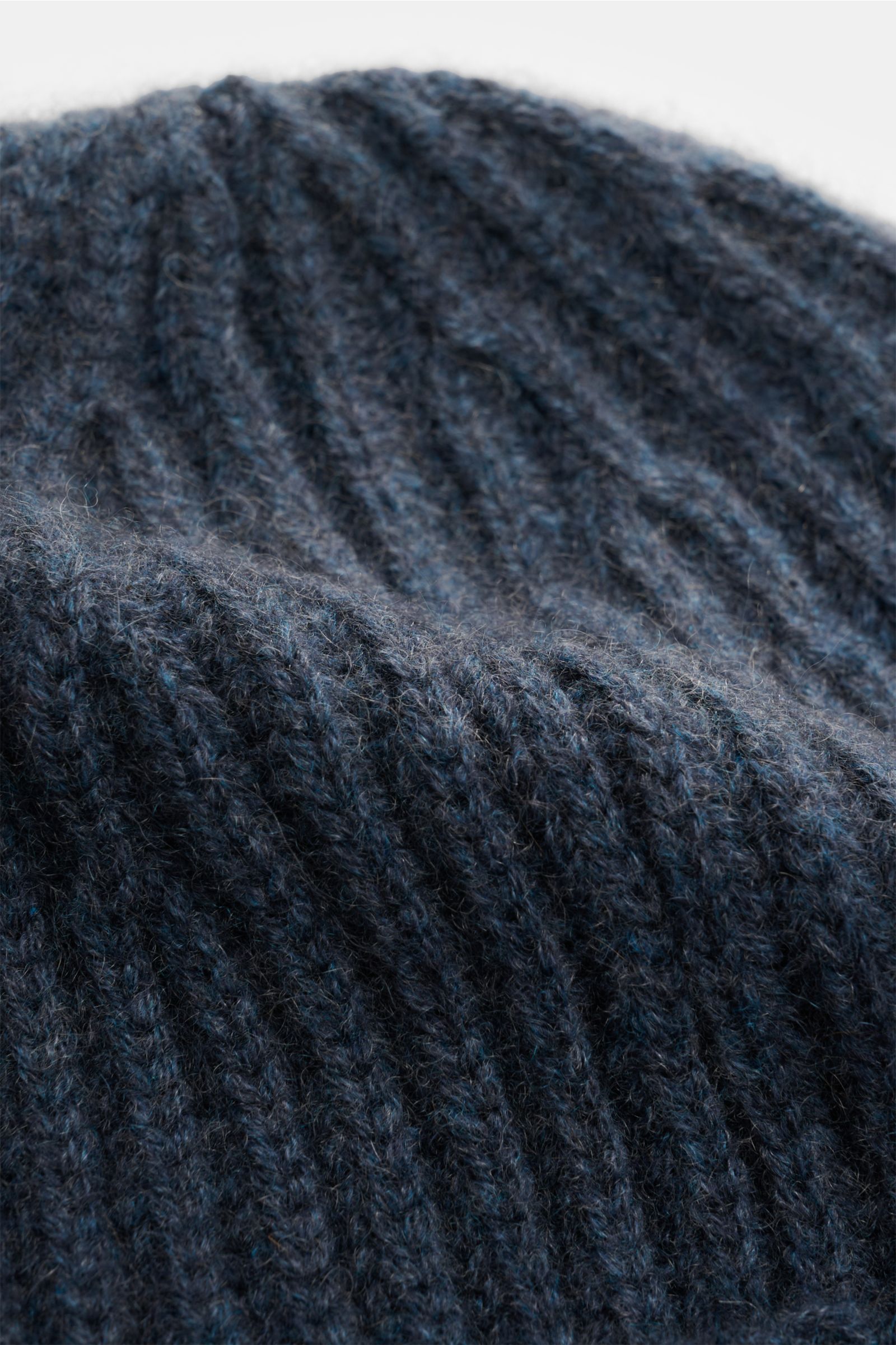 Close-up top view of the Lisa Yang Cashmere Mütze 'Menton' graublau, a soft, medium-knit gray-blue cashmere beanie with a classic cuff and patent stitch pattern, offering luxury warmth and style. Luxus für kalte Tage – die Mütze 'Menton' von LISA YANG bri