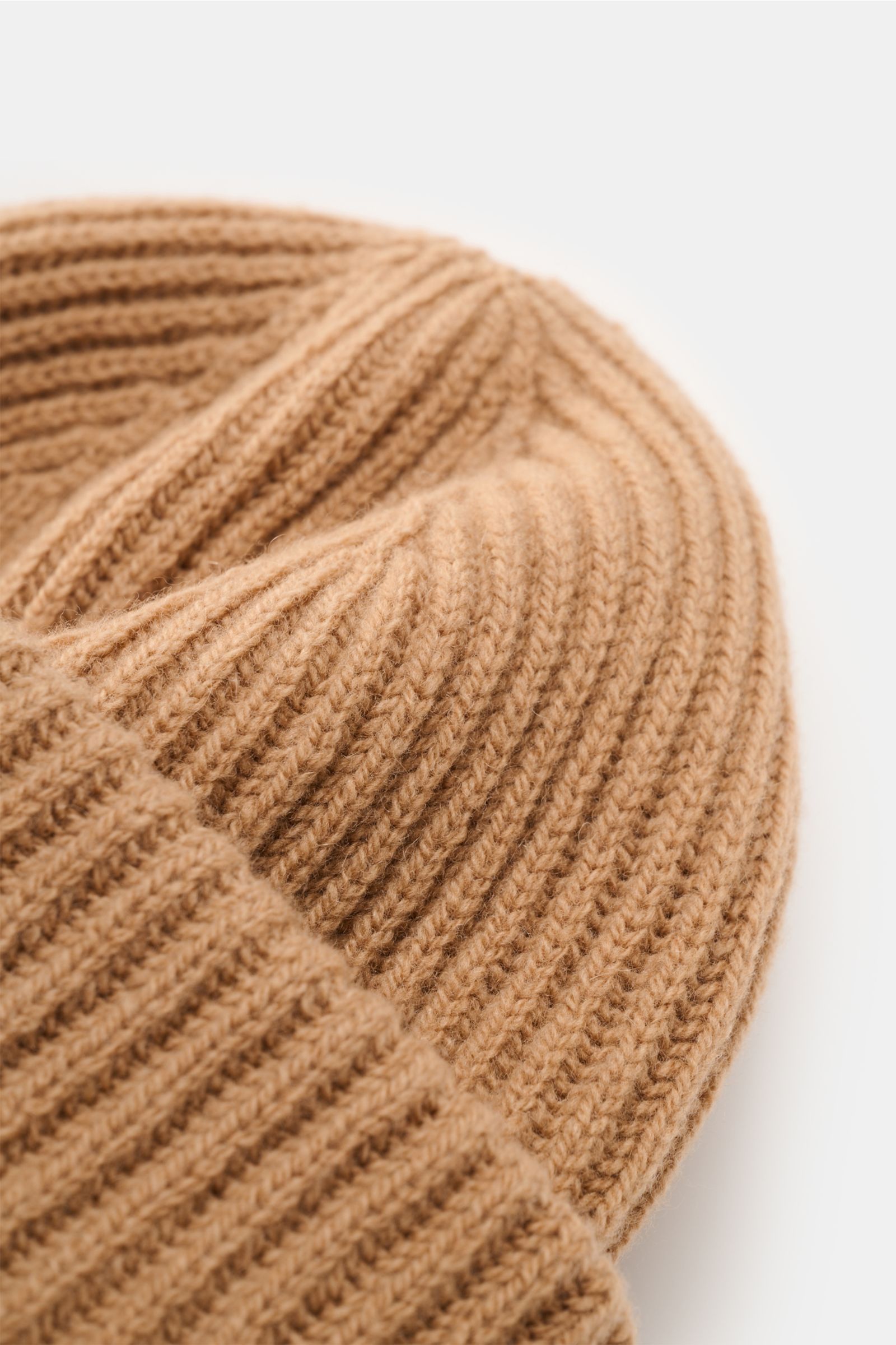 A close-up, top-side view of the A.P.C. Wollmütze 'Michelle' hellbraun, a heavy rib-knit wool and cashmere beanie with a soft texture and wide cuff. Französische Coolness für den Winter: Die Wollmütze 'Michelle' von A.P.C. wurde in schwerem Rippstrick aus