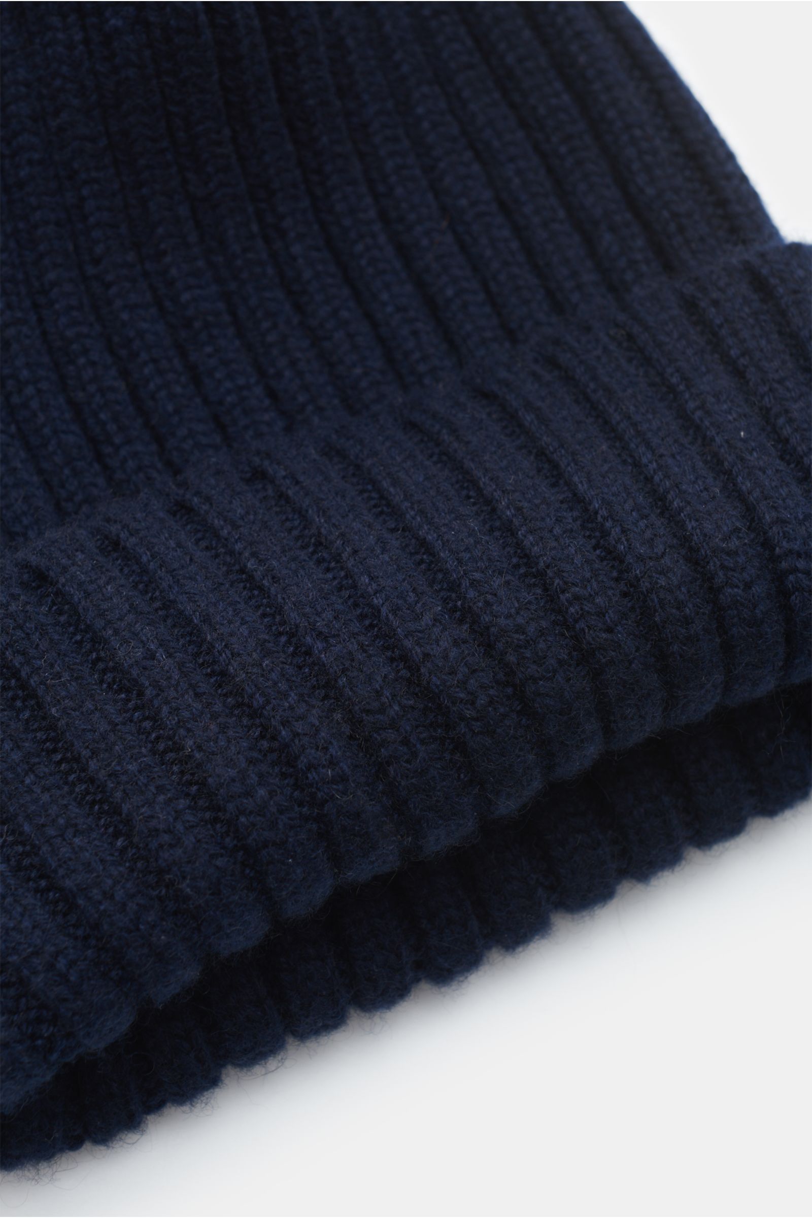 Fedeli Cashmere Mütze navy aus reiner, weicher Cashmere in breitem Rippstrick mit variablem Umschlag, Nahaufnahme von schräger Seitenperspektive.