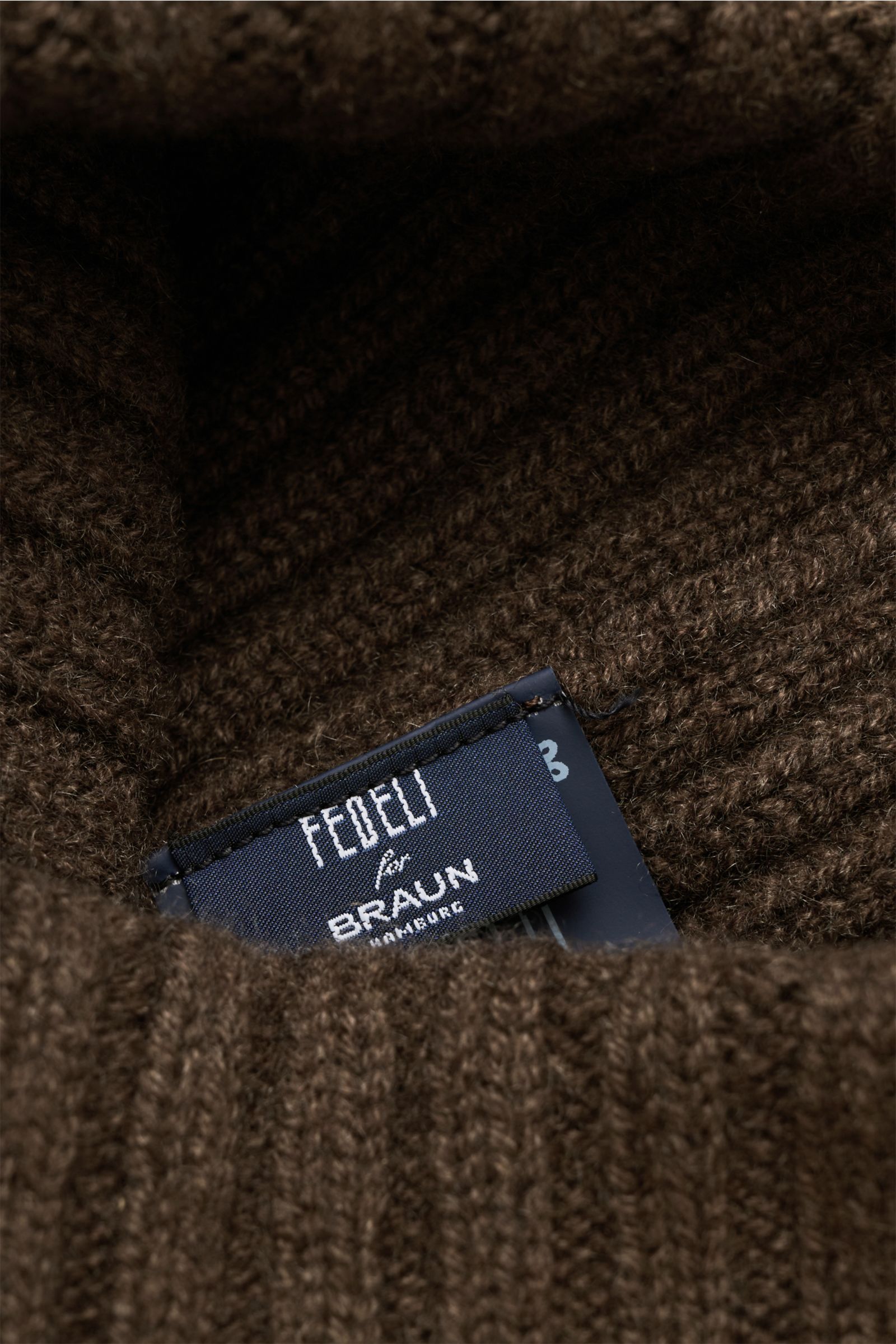 Nahaufnahme aus schräger Perspektive der braunen Fedeli Cashmere Mütze mit breitem Rippstrick und variablen Umschlag, weicher Griff.