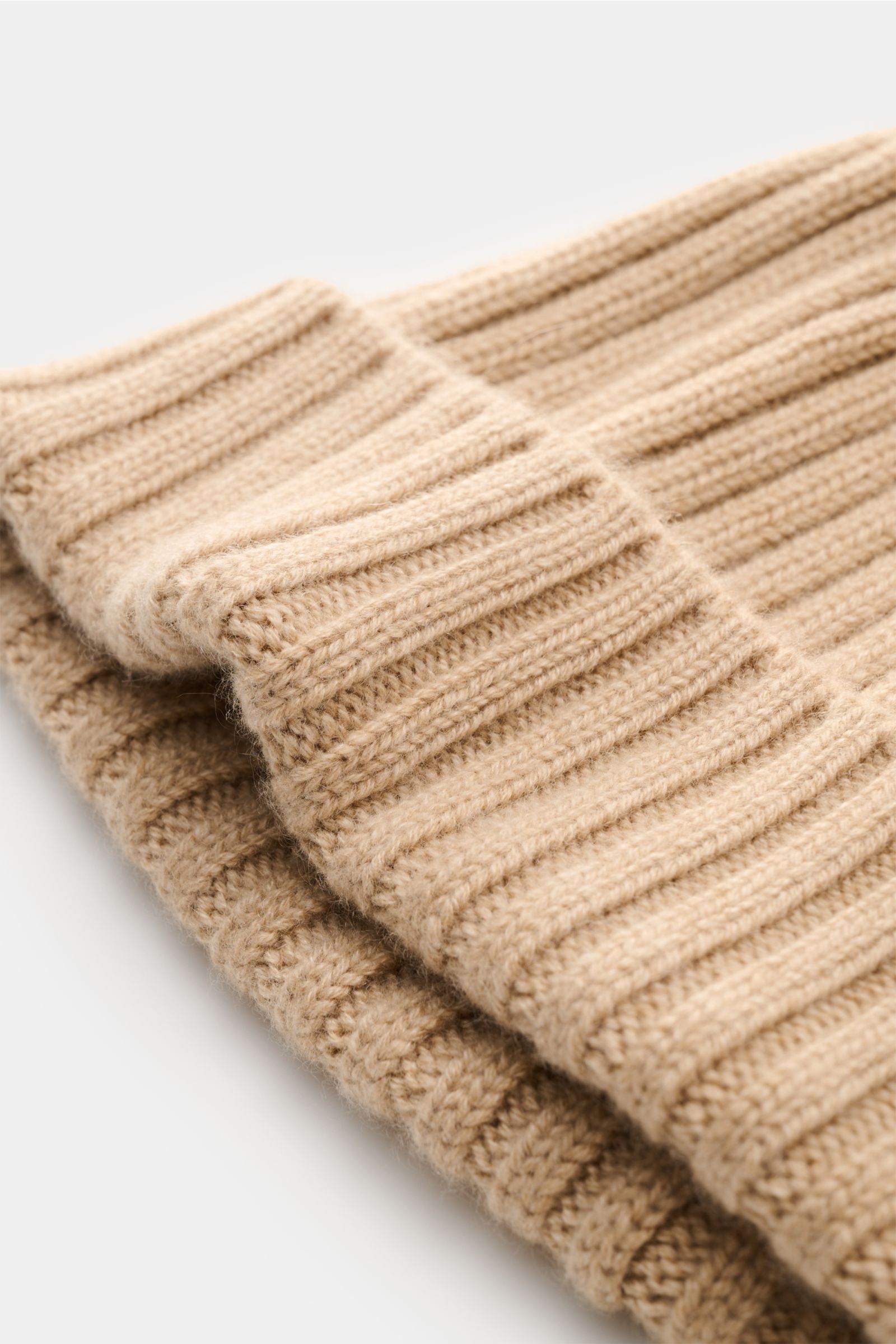 Fedeli Cashmere beanie beige shown from a close-up side angle, featuring wide rib knit, adjustable turn-up, and soft pure cashmere texture. With this comfortable beanie, Italian label FEDELI presents a sophisticated accessory in smooth cashmere to give wi