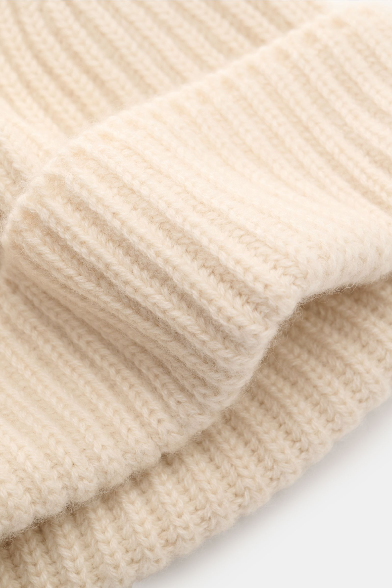 Nahaufnahme der Fedeli Cashmere Mütze 'Alfredo' creme aus reinem Cashmere mit grobem Rippstrick und variablem Umschlag, weicher Griff.