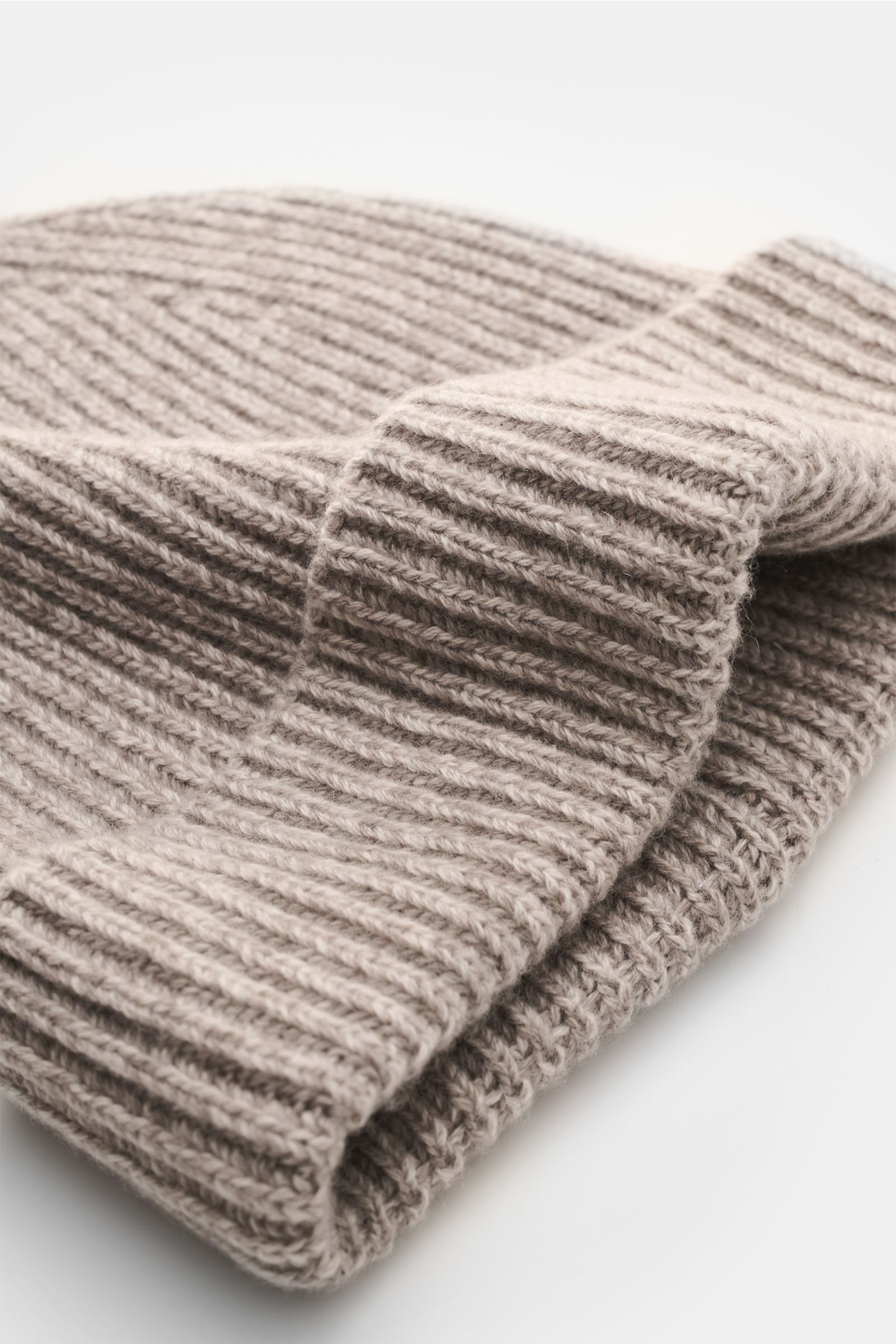 Agnona Cashmere Mütze sand meliert, folded knit hat photographed close-up from a side angle, showing patent stitch pattern, soft texture, and narrow cuff. Für warme Wintermomente mit Stil: Diese Patentstrickmütze von AGNONA aus reinem Cashmere mit Umschla