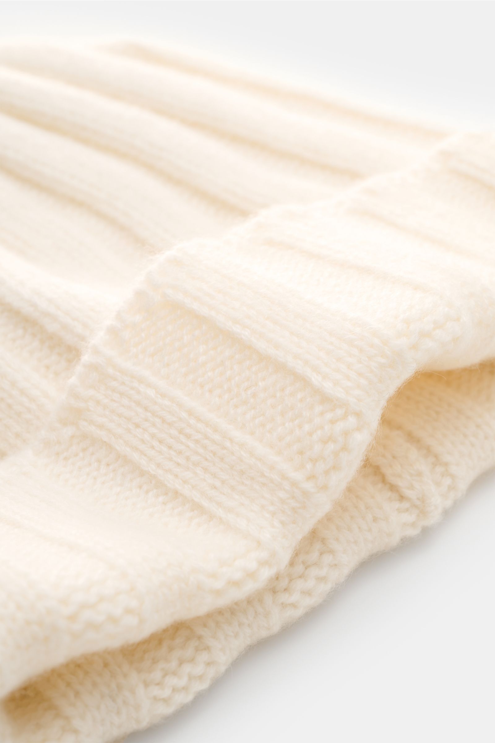 FTC Cashmere Mütze creme, Nahaufnahme schräg von oben, feiner Rippstrick, mittelfeines Strickbild, weicher Griff, schmaler Umschlag mit FTC-Label
