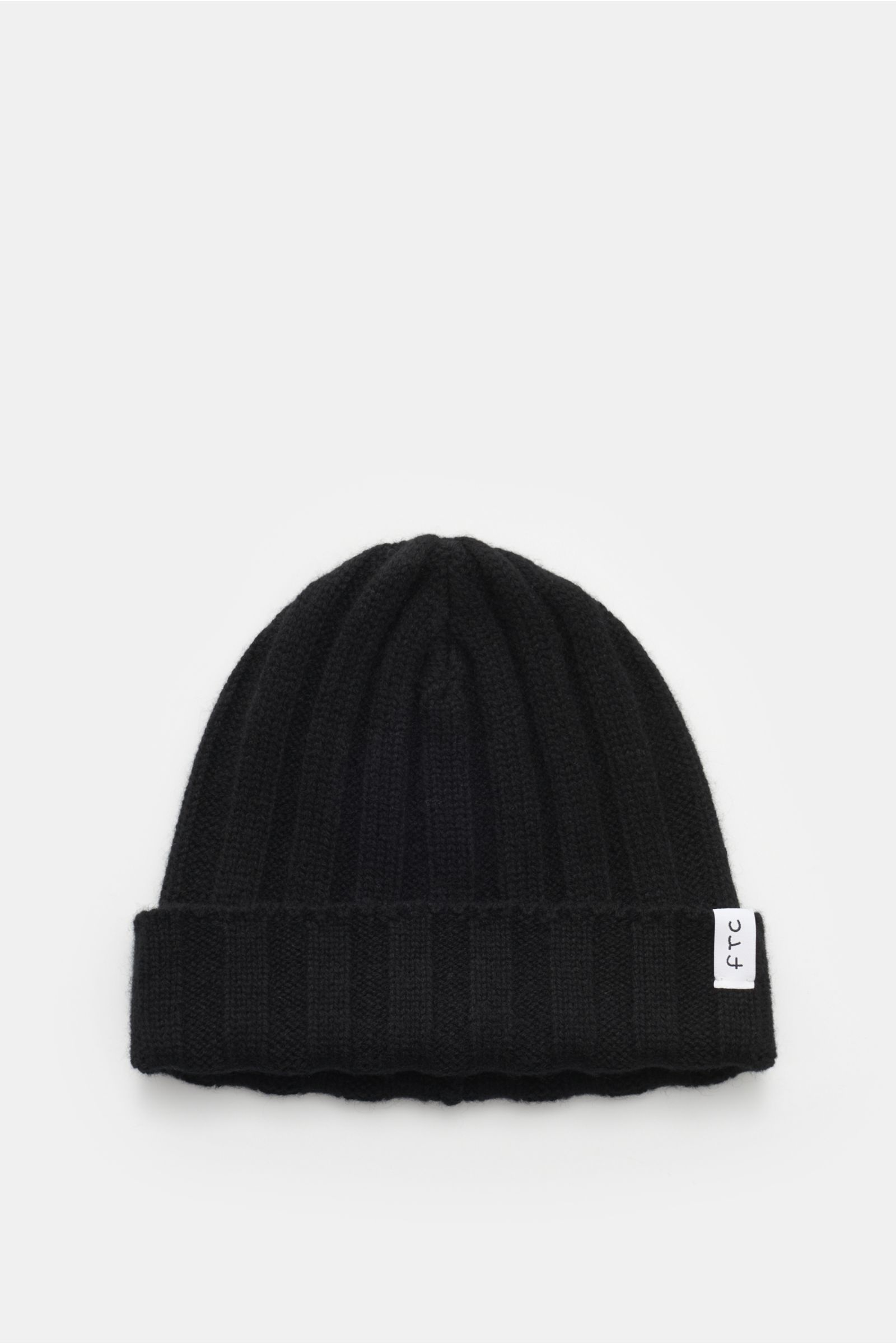 FTC Cashmere Mütze schwarz, von oben fotografiert, feiner Rippstrick, schmaler Umschlag mit FTC-Weblabel, weicher Griff, reiner Cashmere.