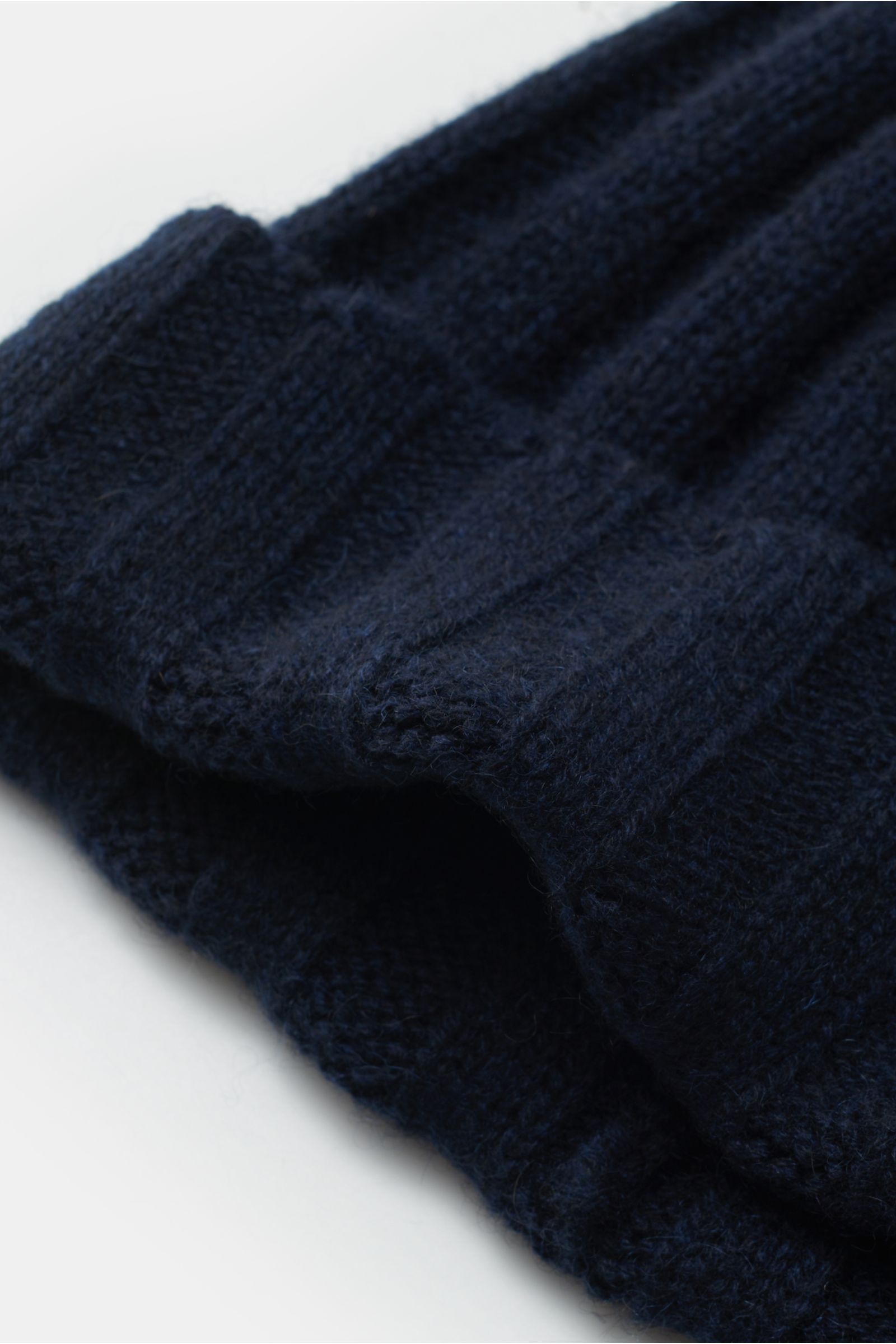 Nahaufnahme einer navyfarbenen FTC Cashmere Mütze navy aus feinem Fair-Trade-Cashmere mit weichem Griff, Rippstrick und schmalem Umschlag.