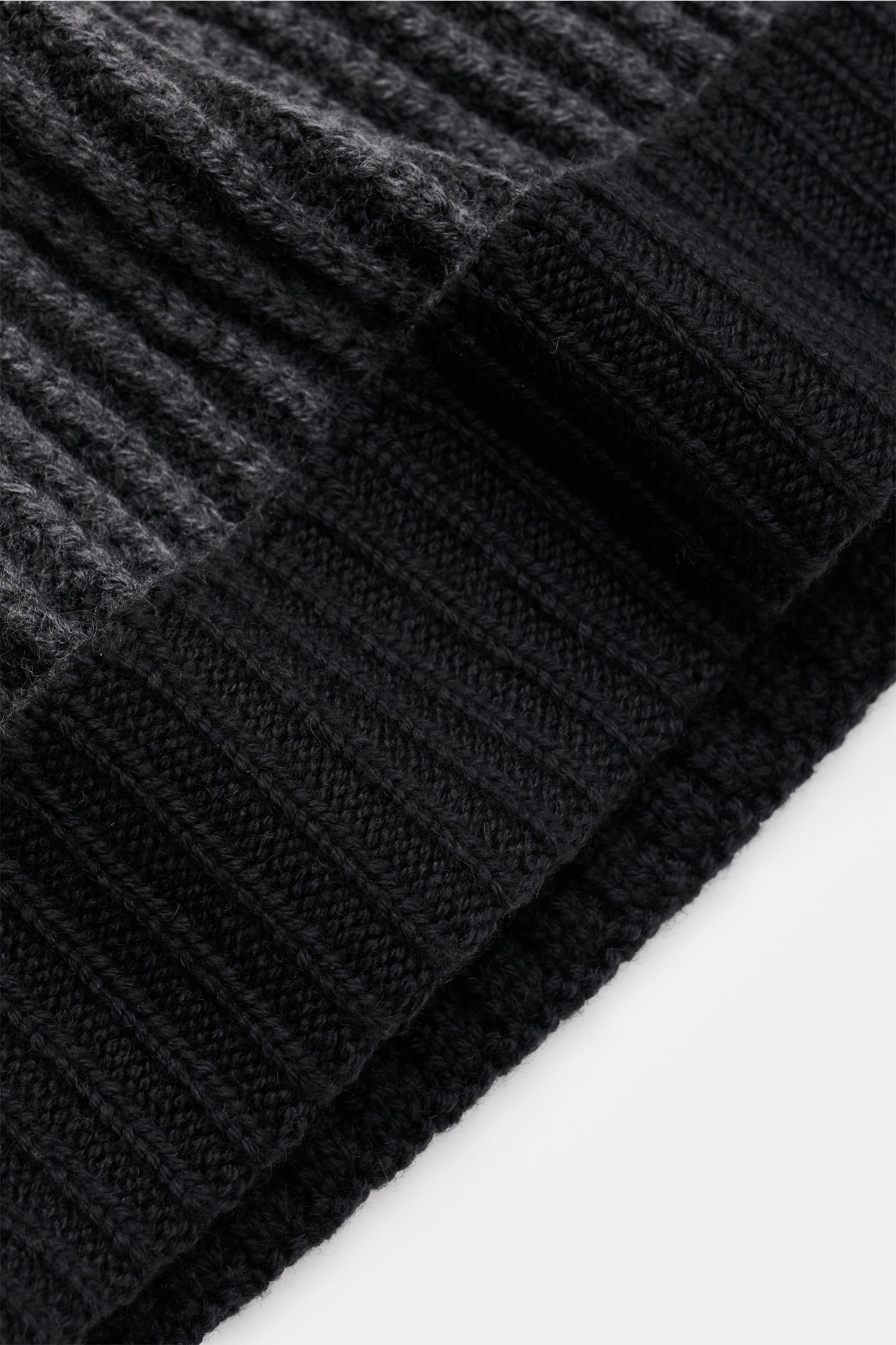 Close-up angled view of the 04651/ A trip in a bag Wollmütze 'Foggy Hat' schwarz showing its soft, ribbed wool fabric and narrow cuff.

Stilvolles Winter-Essential: Die 'Foggy Hat' Wollmütze von 04651/ A TRIP IN A BAG wird mit ihrem legeren vintage Loo