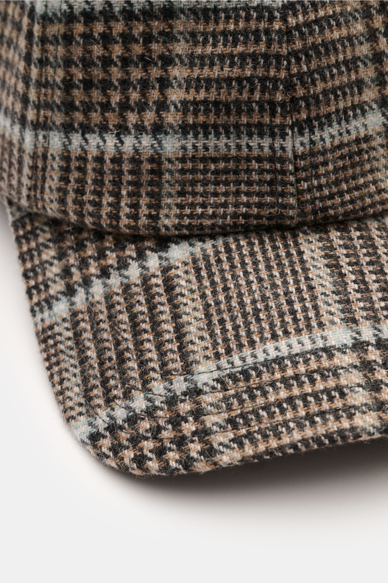 Close-up angled view of the 04651/ A trip in a bag Baseball-Cap 'Check' hellbraun/schwarz/rauchblau kariert, showing its classic Glencheck pattern in brown, black, and smoky blue. This stylish baseball cap features a mix of cotton and microfiber for a sof