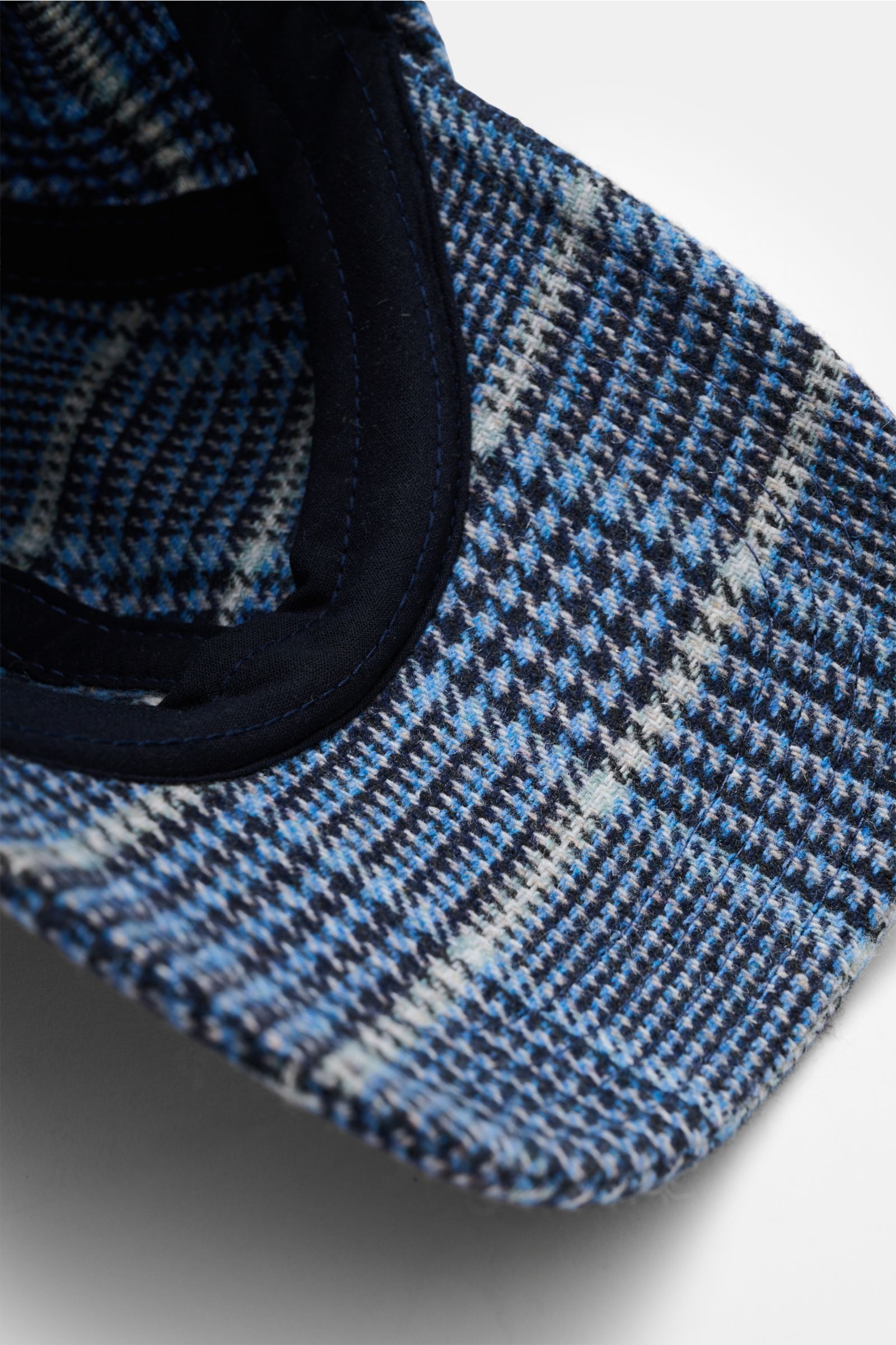 Nahaufnahme der 04651/ A trip in a bag Baseball-Cap 'Check' rauchblau/schwarz/hellgrau kariert mit Glencheckmuster, weichem Griff und verstellbarem Verschluss, fotografiert von oben schräg.