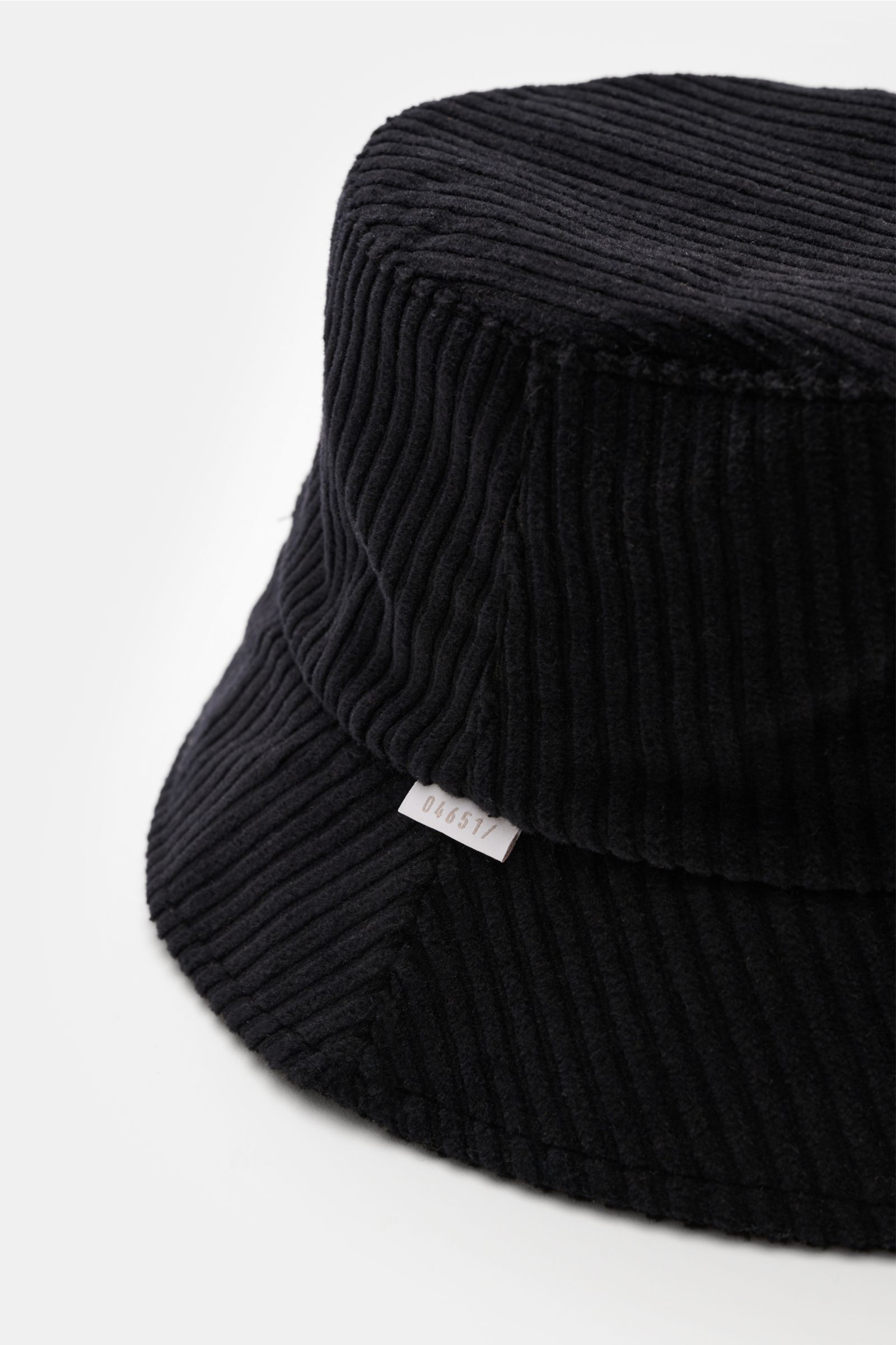 04651/ A trip in a bag Cord Bucket Hat navy aus softem Baumwoll-Cord mit schmaler Krempe, Fleece-Futter und kleinem Weblabel, seitlich fotografiert.