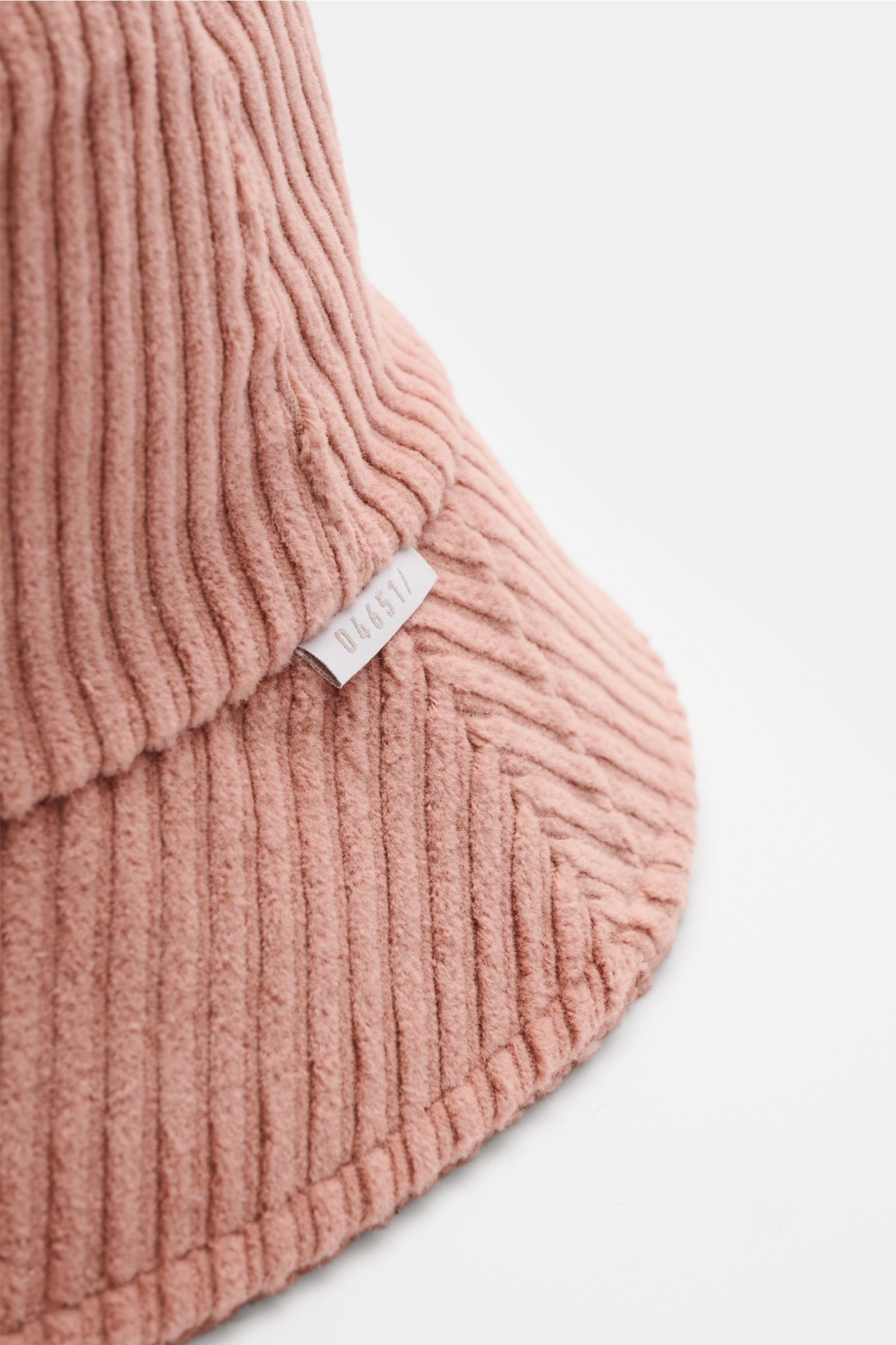 Nahaufnahme des 04651/ A trip in a bag Cord Bucket Hat altrosa aus softem Baumwoll-Cord mit schmaler Krempe, Fleece-Futter und kleinem Weblabel, seitliche Perspektive.