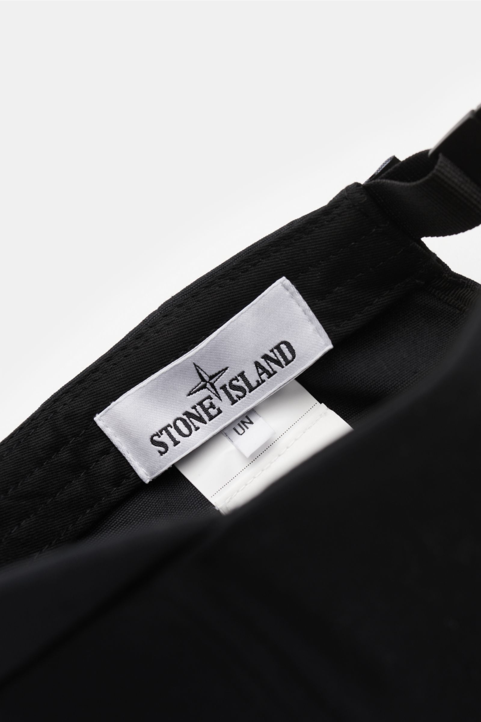 Close-up inside view of the Stone Island Baseball-Cap schwarz showing the white Stone Island label on the pure cotton black fabric with adjustable strap.

Description: Lässig mit Stil: Diese Baseball-Cap aus reiner Baumwolle von STONE ISLAND ergänzt Ih