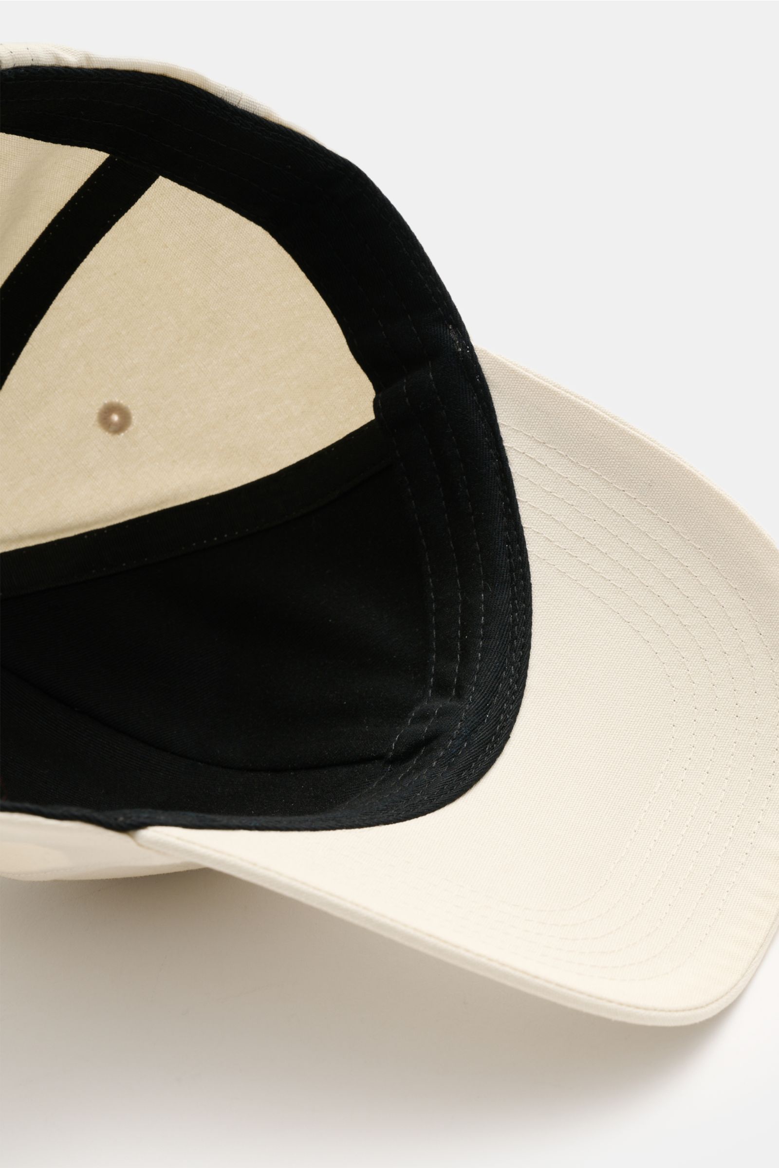 Stone Island Baseball-Cap creme aus reiner Baumwolle, von unten fotografiert, mit gebogenem Schirm, tonalem Kompass-Stitching und verstellbarem Verschluss.