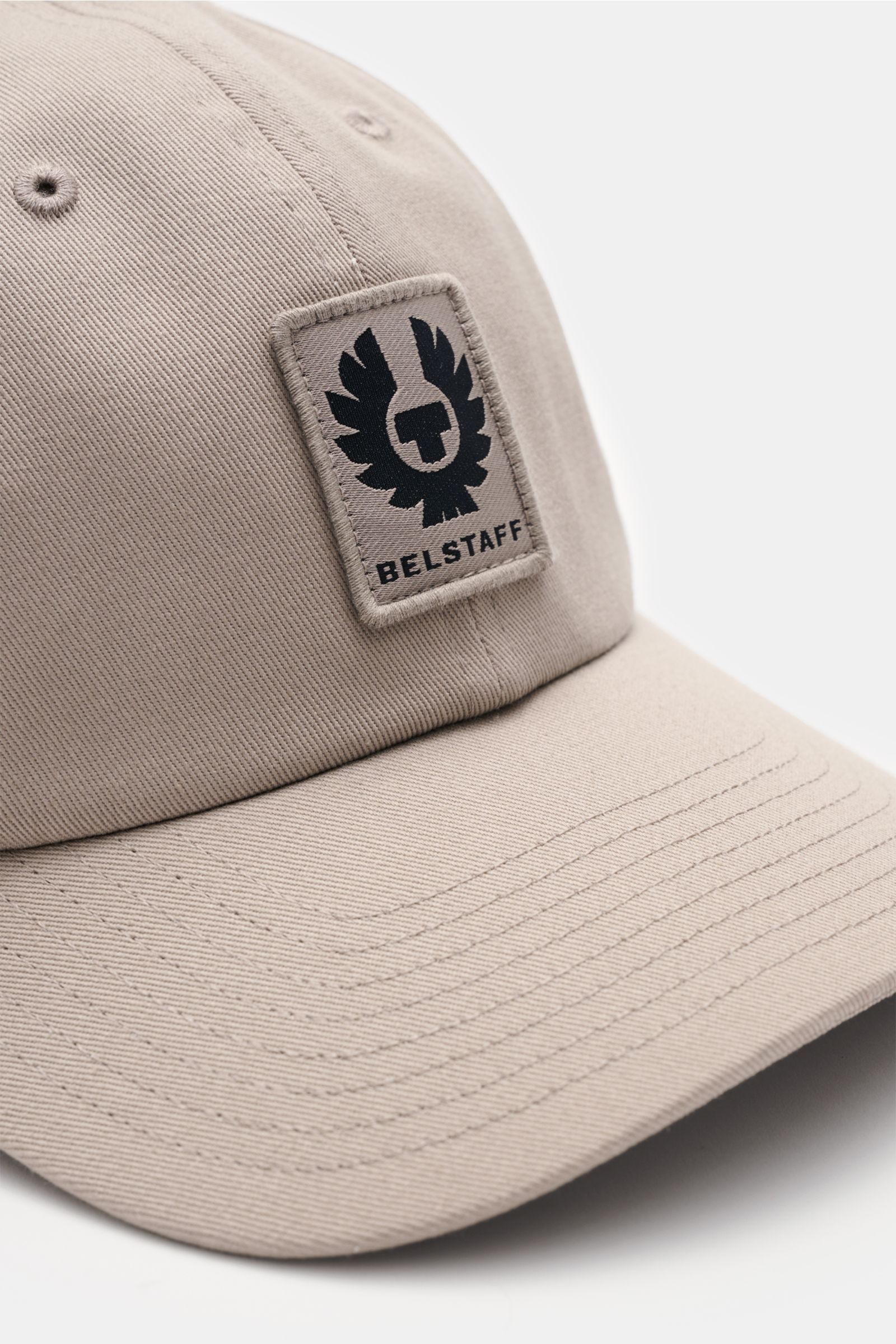 Belstaff Baseball-Cap taupe shown close-up from front-left, made of pure cotton with robust twill structure, featuring BELSTAFF weblabel and adjustable closure.