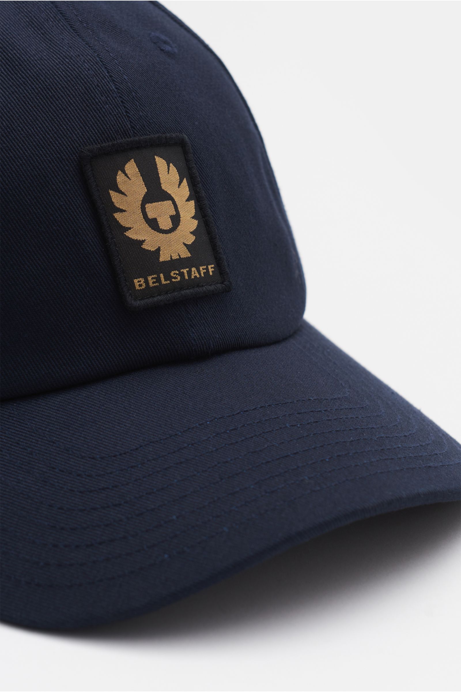 Close-up front-side view of Belstaff Baseball-Cap dark navy in robust cotton twill, featuring a BELSTAFF woven label on the front and adjustable closure.

Description: Für sonnige Tage: Die Baseball-Cap aus robustem Baumwolltwill mit Weblabel auf der F