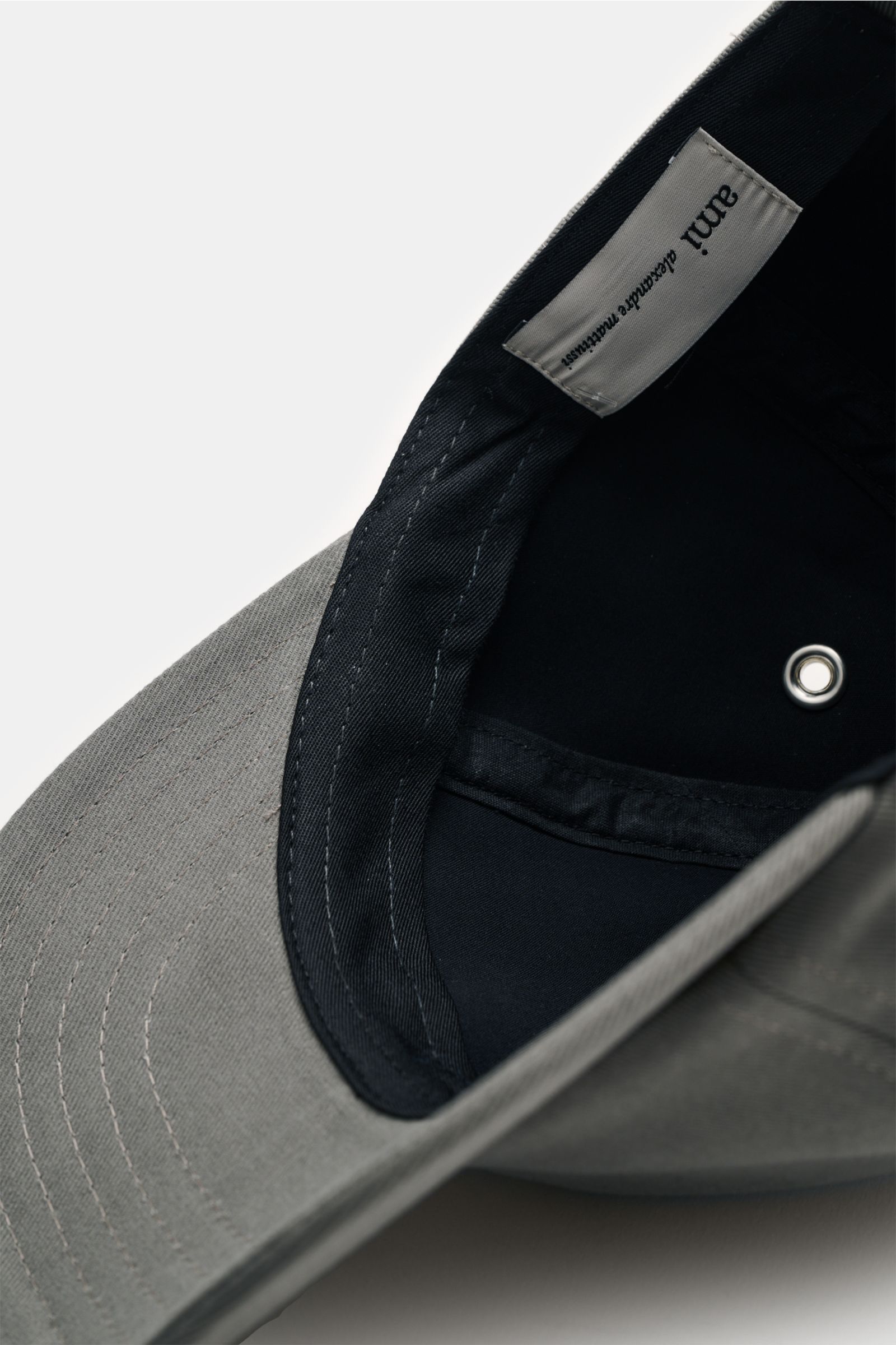 Close-up inside view of the Ami Paris Baseball-Cap dunkelgrau showing the grey cotton fabric, soft black inner lining, and label.

Description: A french affair: Diese Baseball-Cap aus reiner Baumwolle von AMI PARIS ergänzt Ihren Look stilvoll und wird 