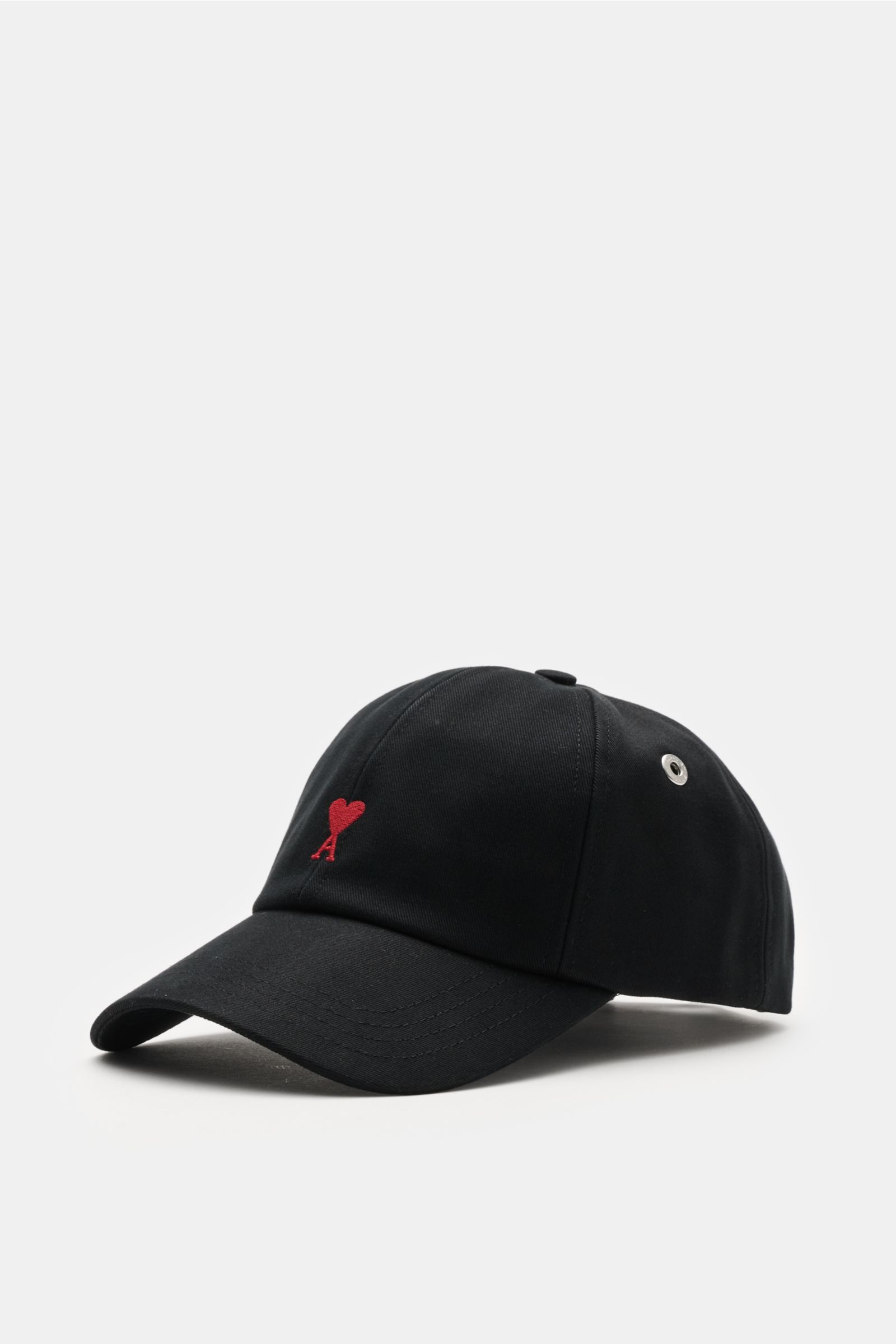 Ami Paris Baseball-Cap schwarz shown from a front-side angle, made of pure cotton with a soft touch, curved brim, adjustable closure, and a red heart logo with contrasting stitching on the front. A french affair: Diese Baseball-Cap aus reiner Baumwolle