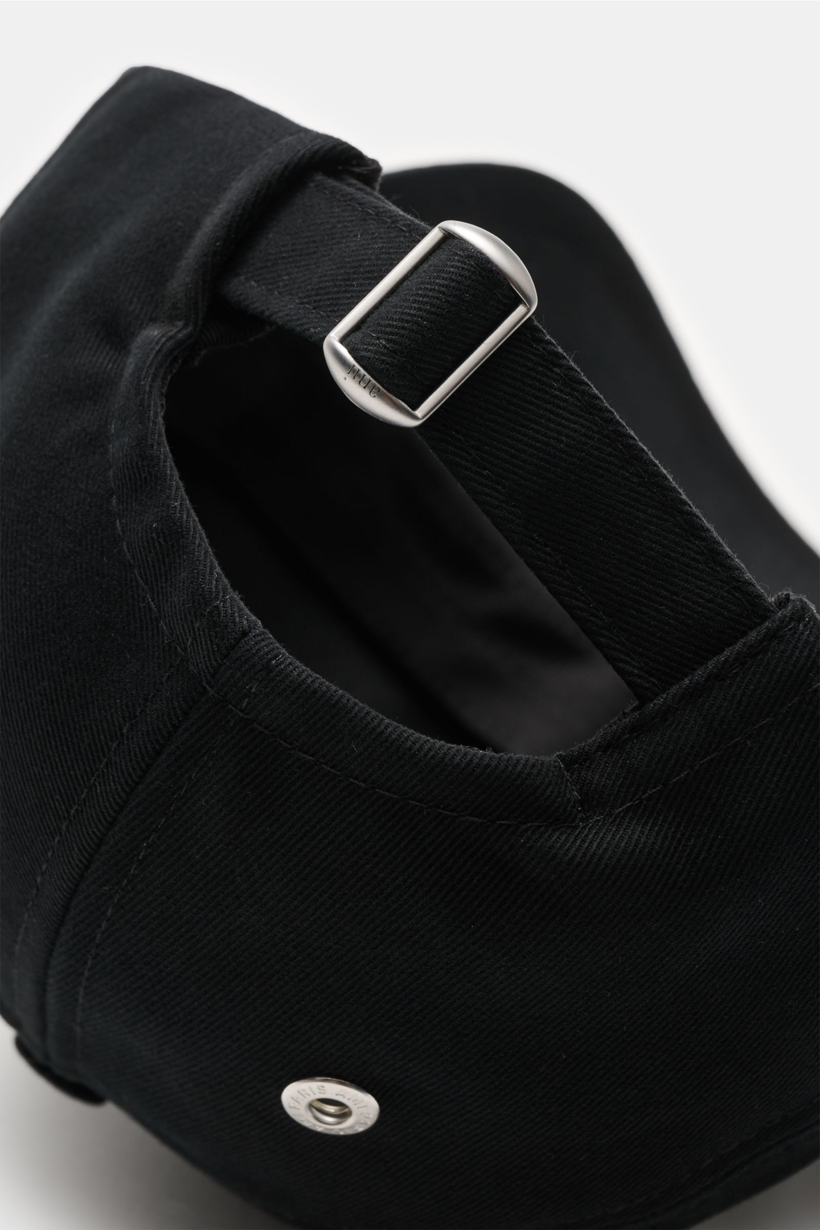 Ami Paris Baseball-Cap schwarz shown from the rear close-up, featuring pure cotton, soft touch, curved brim, contrast logo stitching, and adjustable strap with metal buckle. A french affair: Diese Baseball-Cap aus reiner Baumwolle von AMI PARIS ergänzt