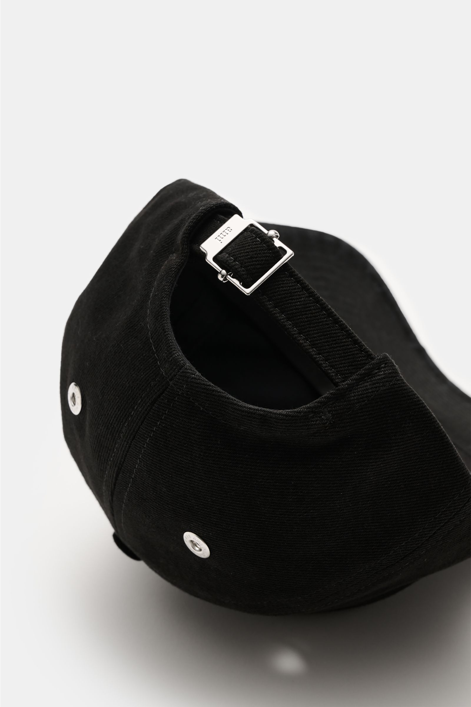 Ami Paris Baseball-Cap schwarz shown from the back with adjustable strap and silver buckle, made of pure cotton with soft feel and curved brim. A french affair: Diese Baseball-Cap aus reiner Baumwolle von AMI PARIS ergänzt Ihren Look stilvoll und wird von