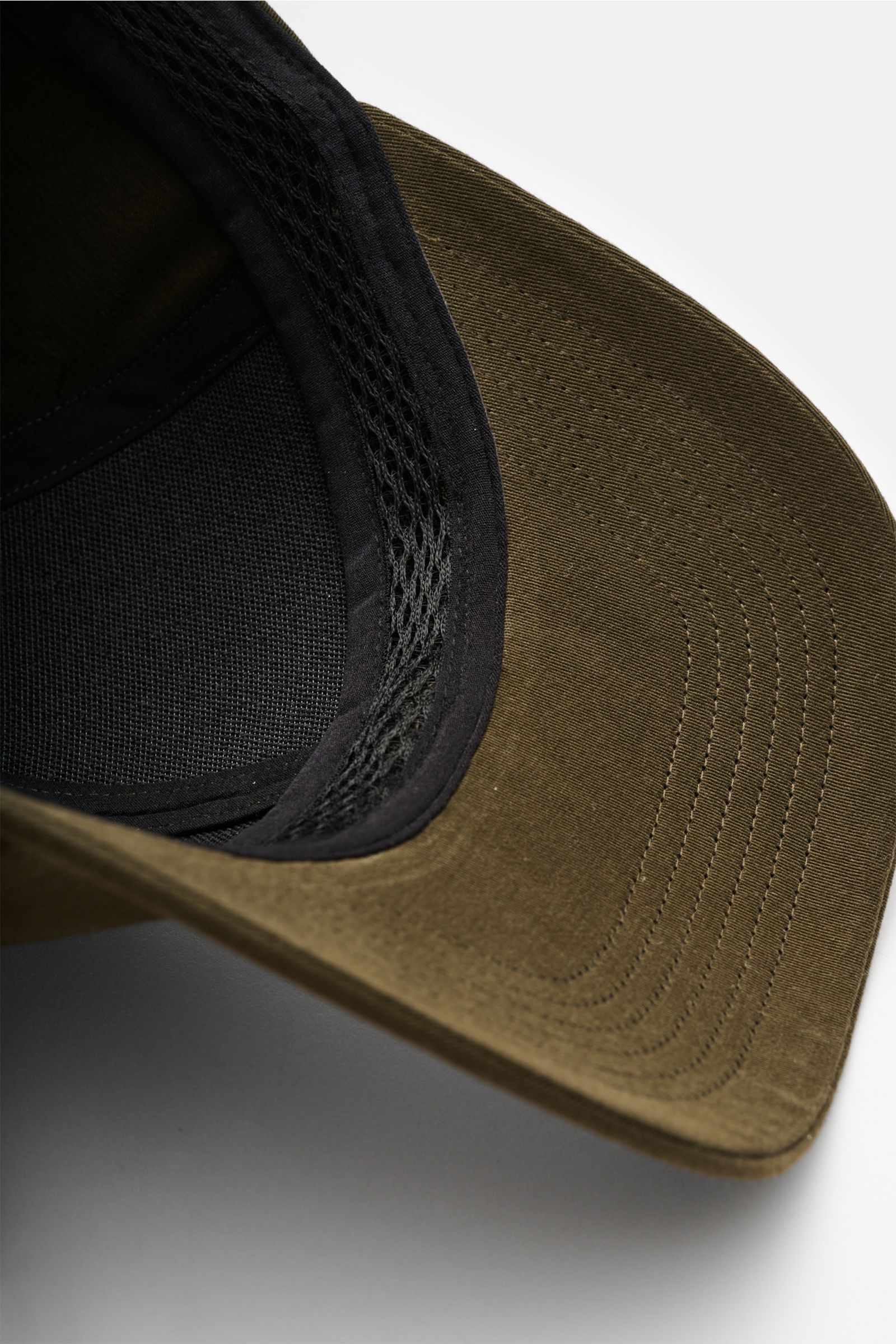 Close-up from above of the inside and brim of the C.P. Company Baseball-Cap khaki, made of pure cotton gabardine with fine weave, lightweight, breathable, garment dyed fabric, featuring a 3D logo embroidery and adjustable strap for perfect fit. Die cle