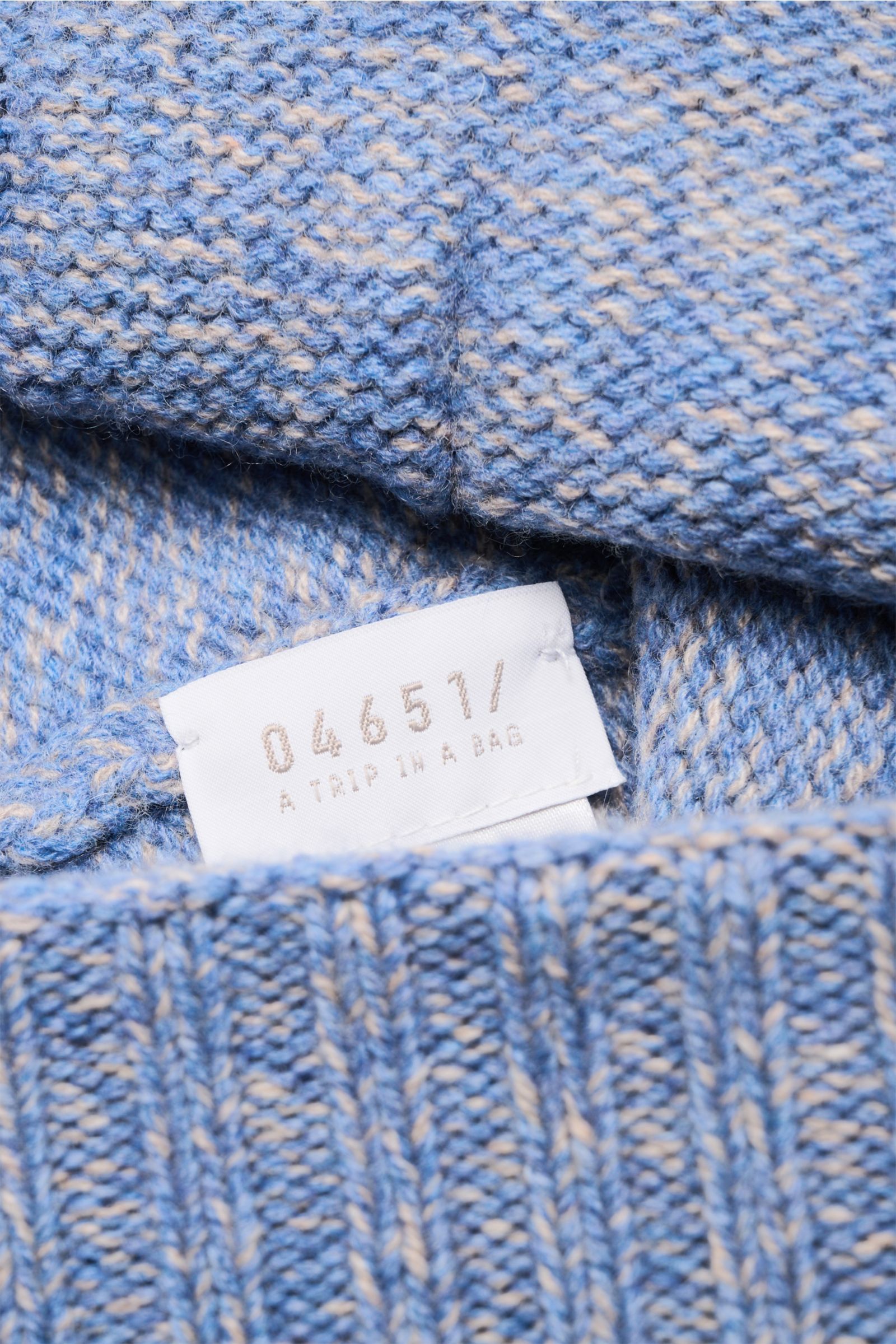 Close-up shot of the inside label and texture of the 04651/ A trip in a bag Beanie 'Mouline Hat' smoky blue/beige mottled, showing its soft wool-cashmere blend and wide turn-up. Stylish all winter long: Create comfortable yet stylish outfits even on cold 