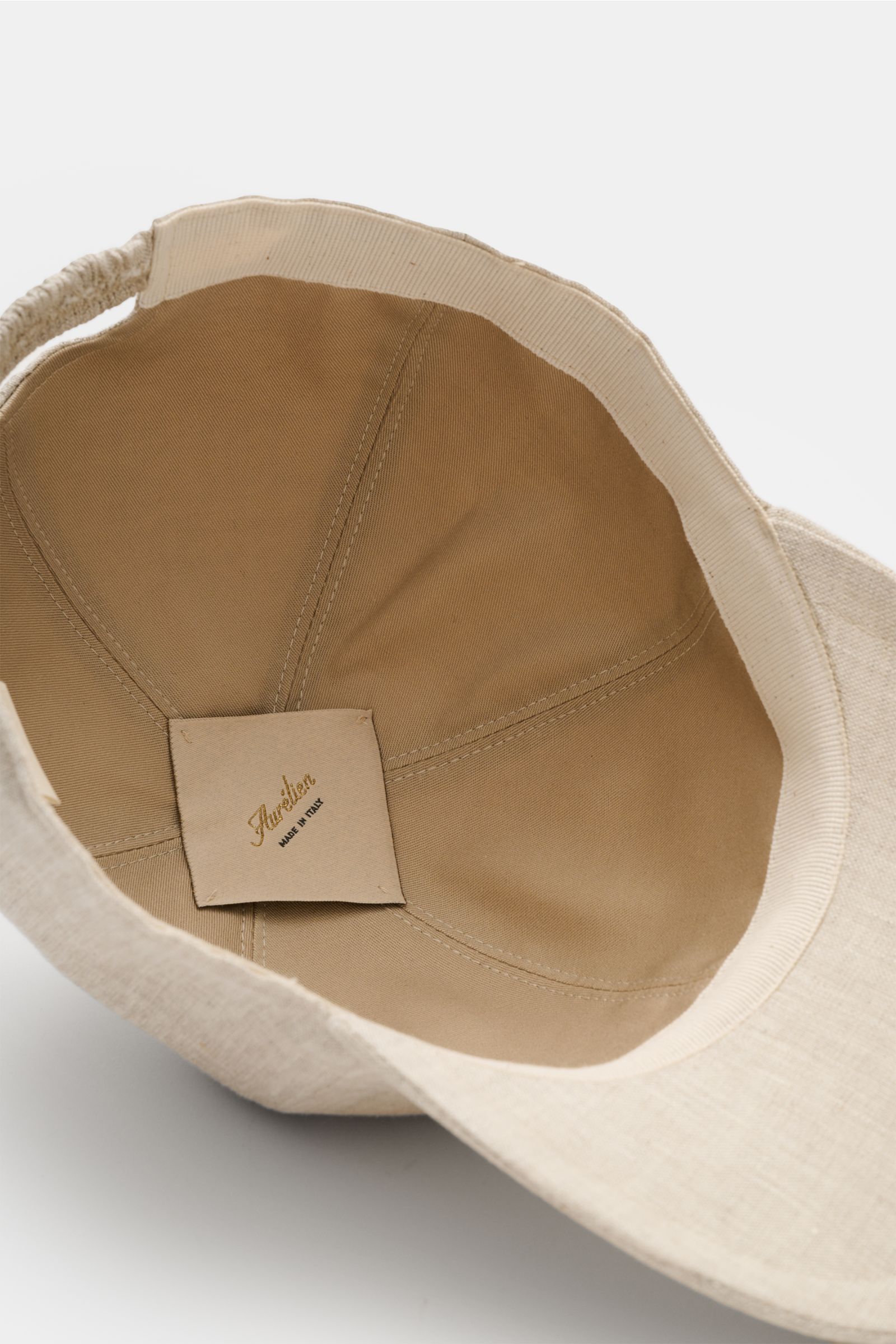 Aurélien Baseball-Cap beige von innen fotografiert, reine Leinenkappe mit Baumwollfutter, Six-Panel-Stil, gebogener Schirm, tonales Logo-Stitching.