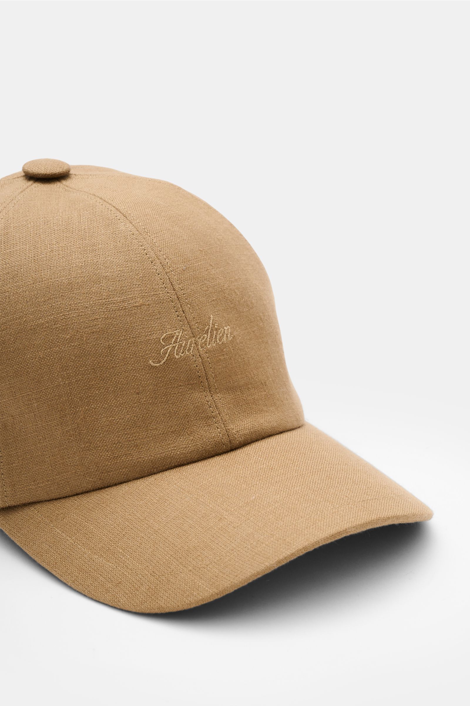 Aurélien Baseball-Cap camel aus reinem Leinen, Six-Panel-Stil mit gebogenem Schirm und tonalem Logo-Stitching, seitliche Nahaufnahme.