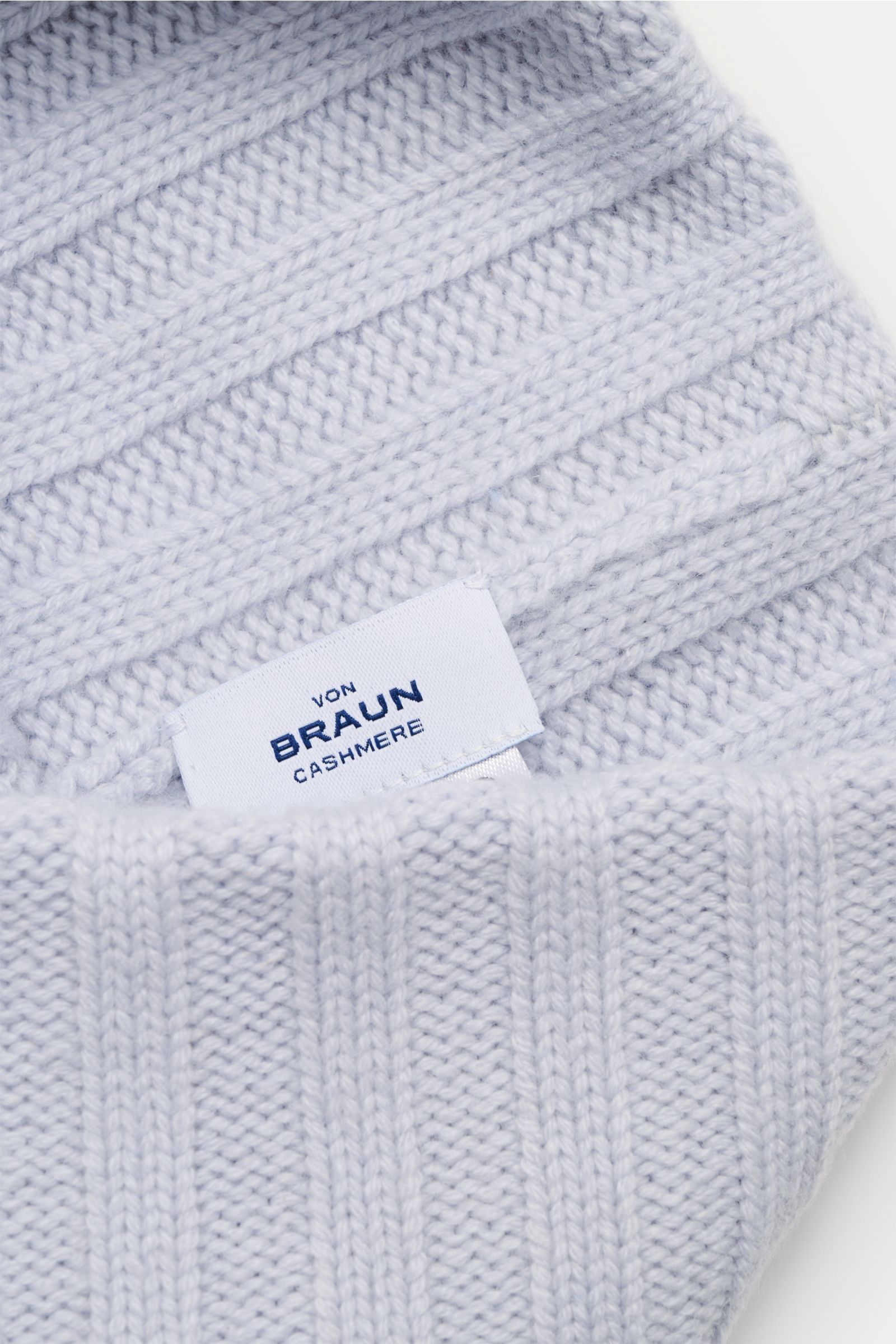 Close-up top-down view of von Braun Cashmere beanie light blue showing fine rib knit pattern and brand label on soft pure cashmere fabric. Whether worn with a classic winter coat or a highly functional down jacket, this soft VON BRAUN knitted beanie made 