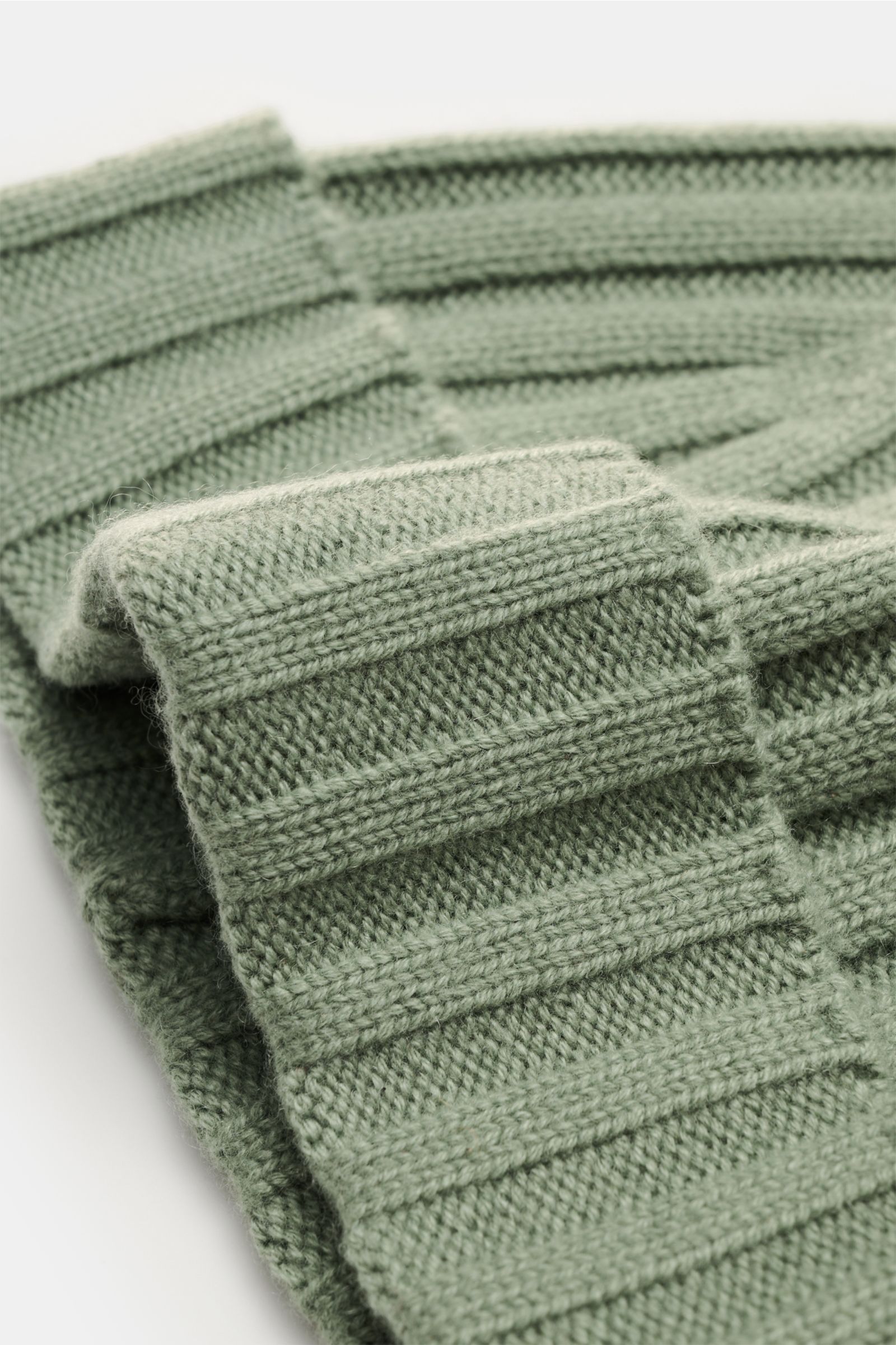 Close-up side view of the von Braun Cashmere beanie sage showing its fine knit, classic rib pattern, and small turn-up in soft pure Mongolian cashmere with a very soft feel. 

Whether worn with a classic winter coat or a highly functional down jacket, 