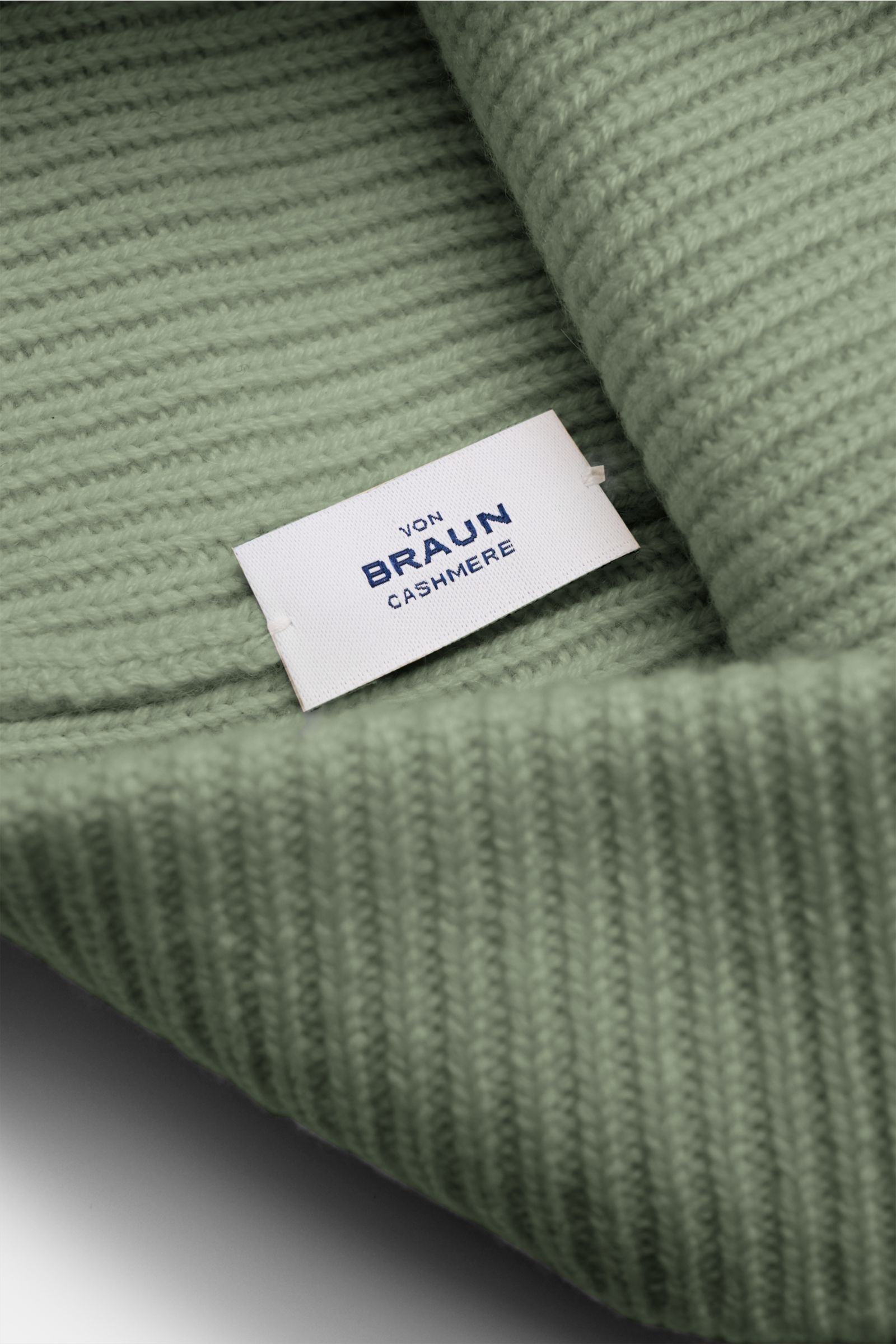 Nahaufnahme der von Braun Cashmere Mütze salbei mit feinem, klassischem Rippstrickmuster und schmalem Umschlag aus sehr weichem, reinem mongolischem Cashmere.