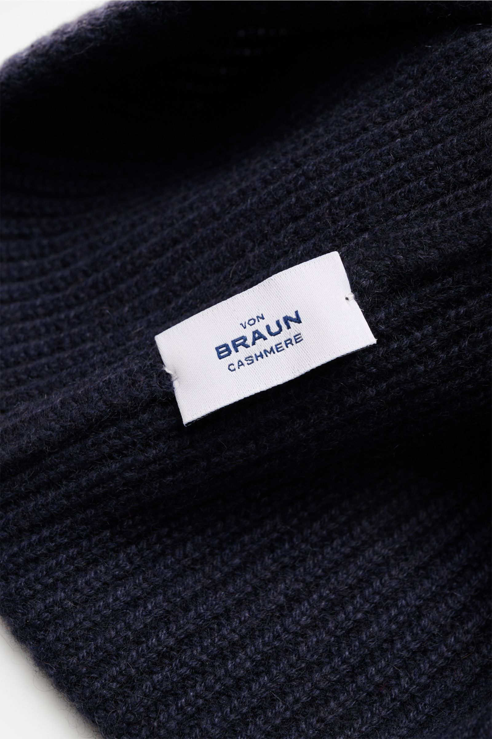 Close-up top-down view of von Braun Cashmere beanie navy in pure cashmere with a soft feel, fine brioche knit, and small turn-up.