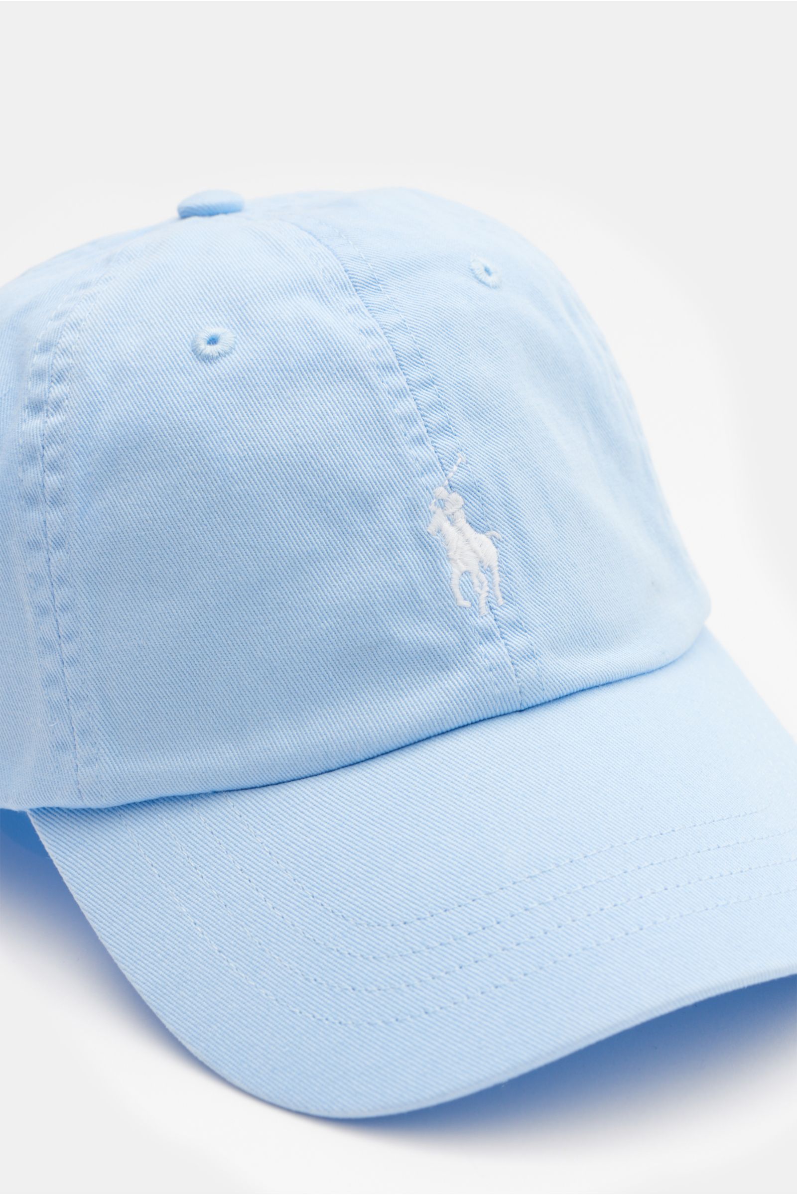 Polo Ralph Lauren Baseball-Cap pastellblau aus reiner Baumwolle, leicht griffig, Sechs-Panel, gebogener Schirm, Logo-Stitching, verstellbar, seitliche Nahaufnahme.