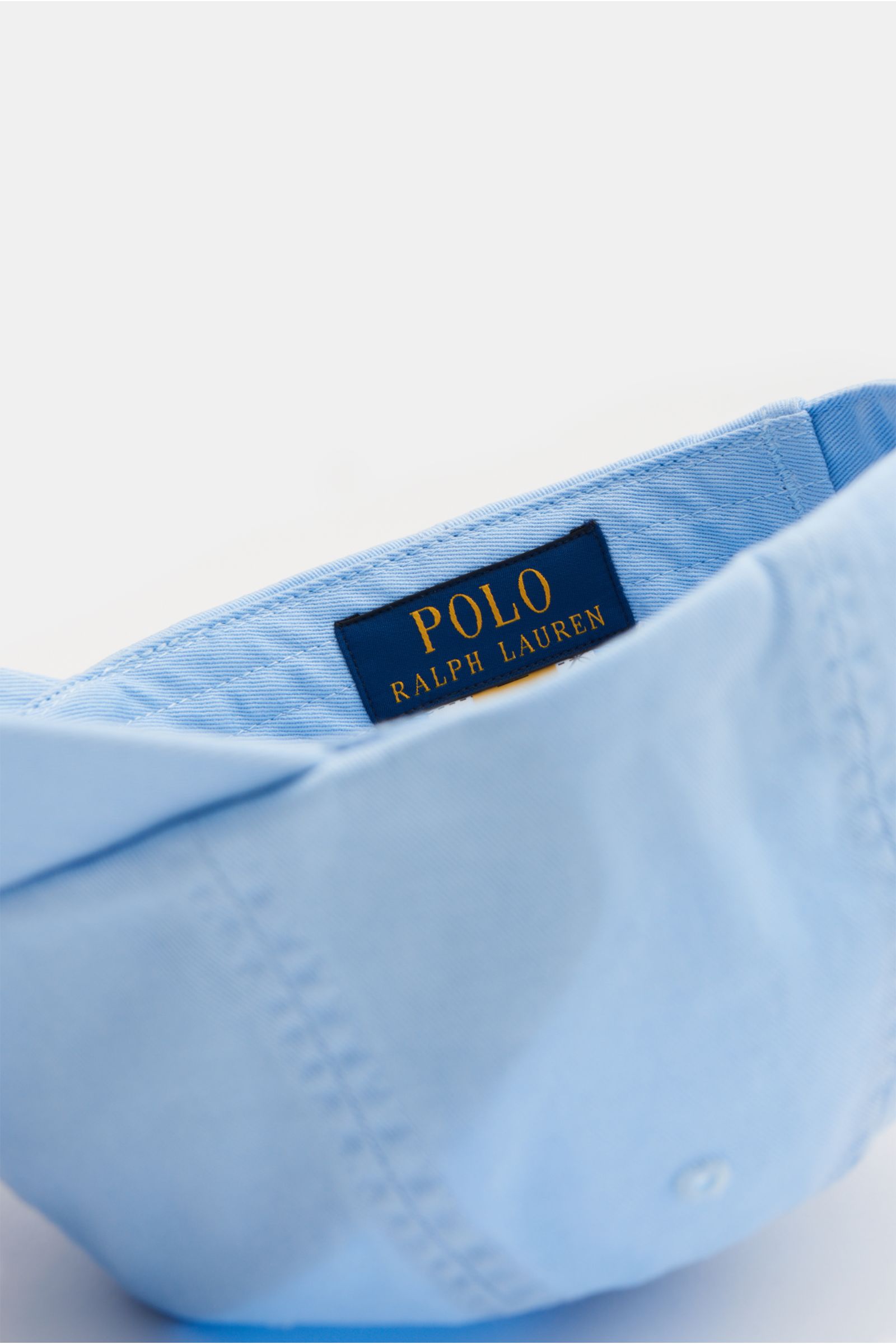 Polo Ralph Lauren Baseball-Cap pastellblau aus reiner Baumwolle, Sechs-Panel-Design, gebogener Schirm, Logo-Stitching, verstellbar, Nahaufnahme innen.
