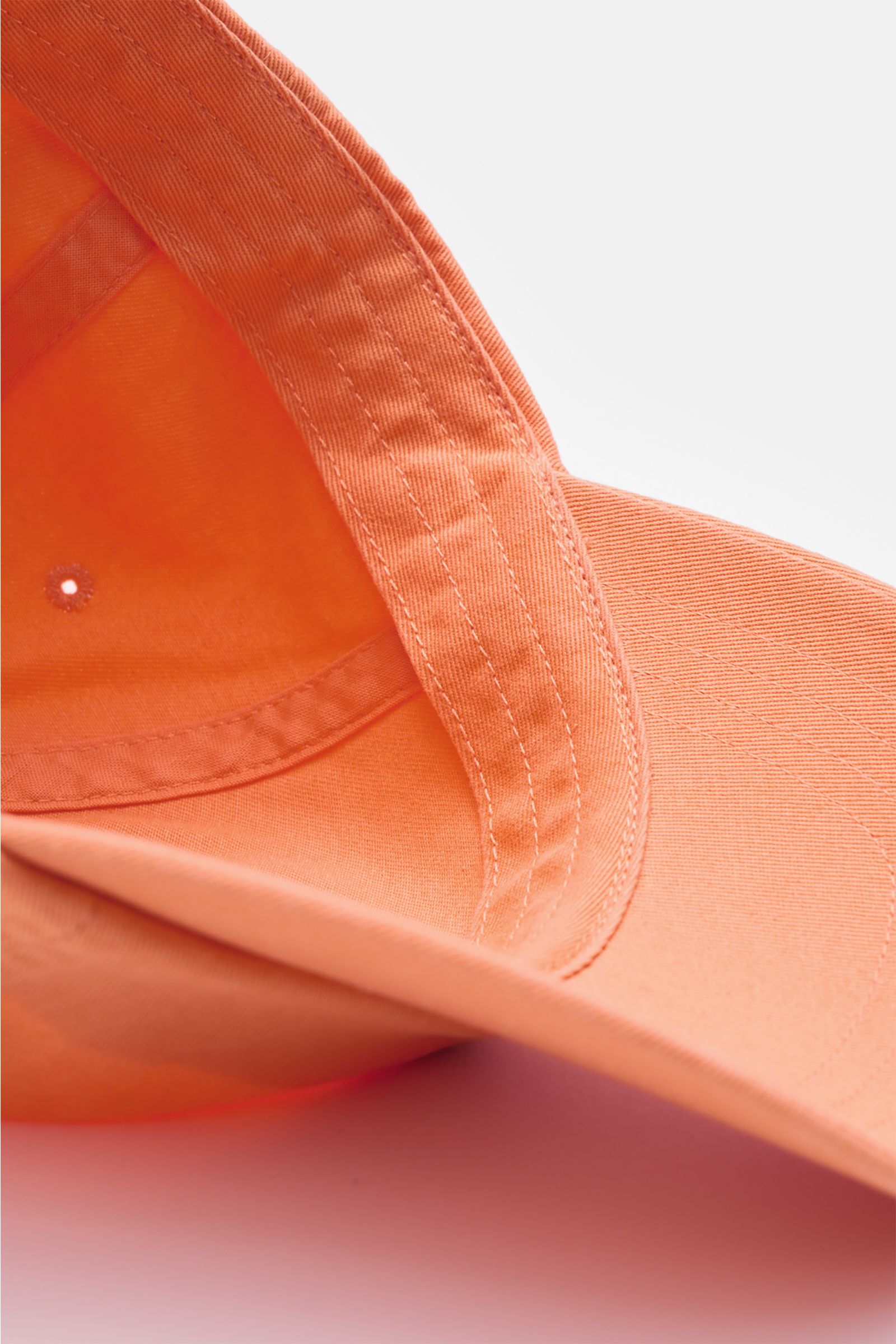 Close-up inside view of the Polo Ralph Lauren Baseball-Cap orange, showing pure cotton fabric, classic six-panel design, logo stitching on front, and adjustable closure, photographed from an angled perspective. Lässige Looks: Die Baseball-Cap von POLO RAL