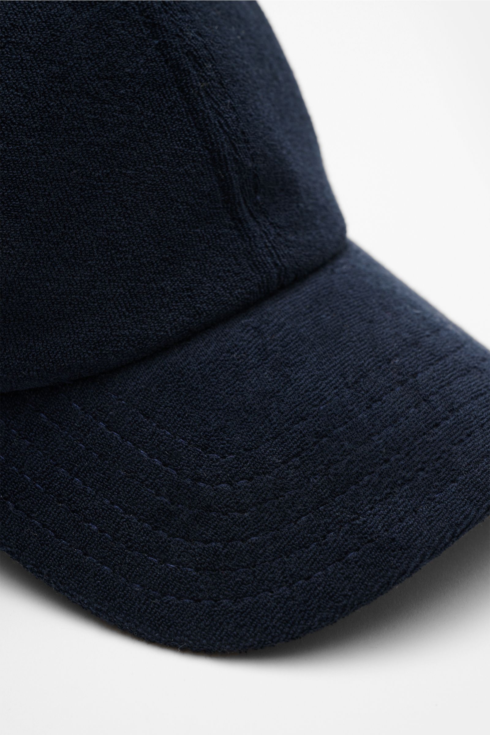 Close-up front side view of the 04651/ A trip in a bag Terry baseball cap 'Terry' navy in soft cotton terry with six panel style and adjustable closure. Spring awakening: This stylish baseball cap in soft terry by label 04651/ A TRIP IN A BAG offers good 