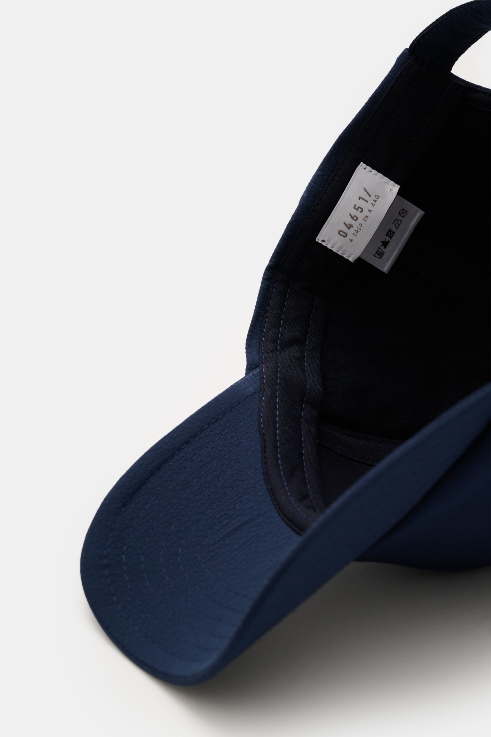 04651/ A trip in a bag Baseball-Cap 'Seersucker' navy in Six-Panel-Stil, verstellbar, aus Microfaser-Baumwolle, Detailansicht von innen.