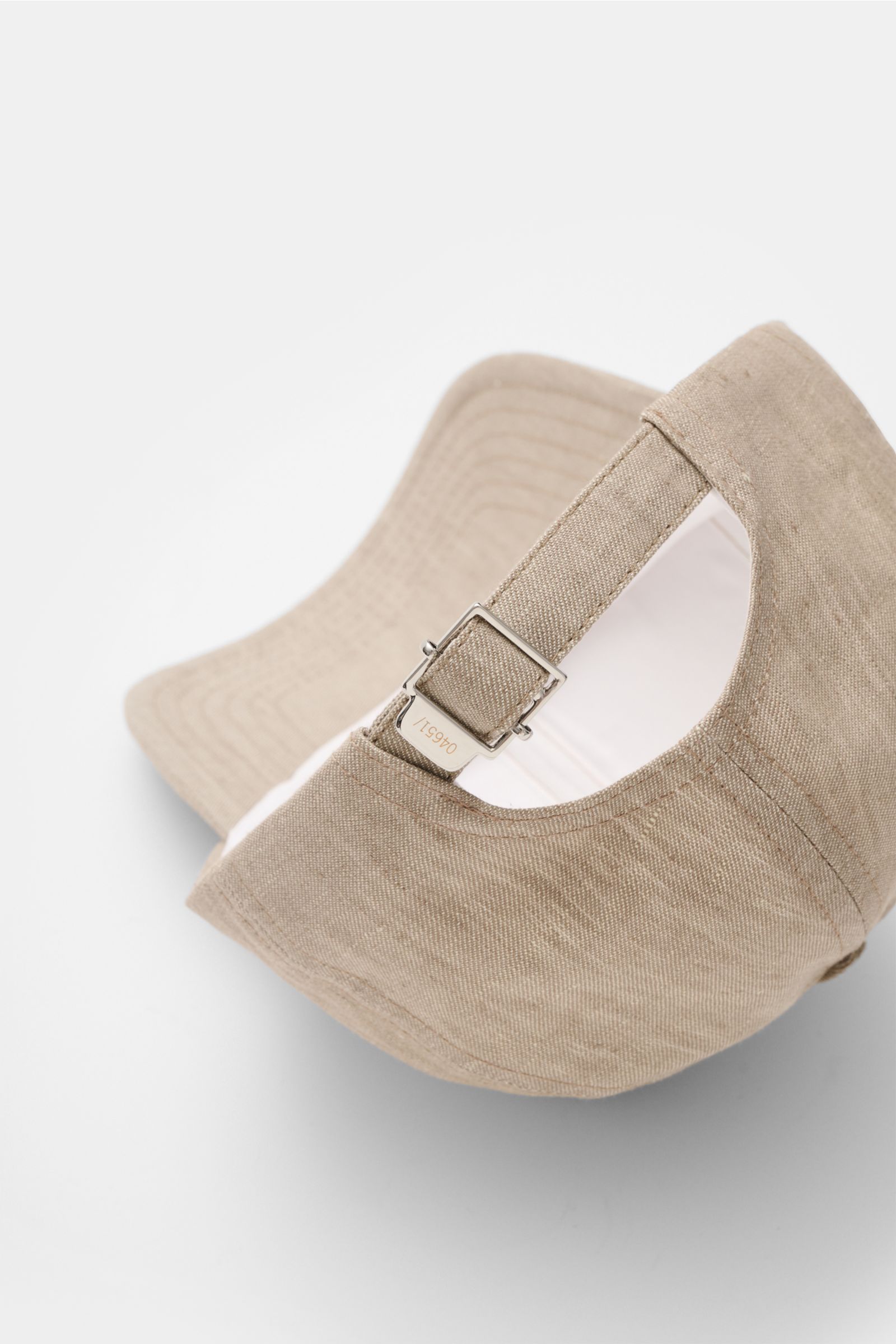 Rear close-up view of the 04651/ A trip in a bag Baseball cap 'Linen' taupe mottled, made of pure linen with a six-panel style and adjustable closure, showcasing a slightly robust texture. Relaxed summer aesthetic: This baseball cap in pure linen by 04651